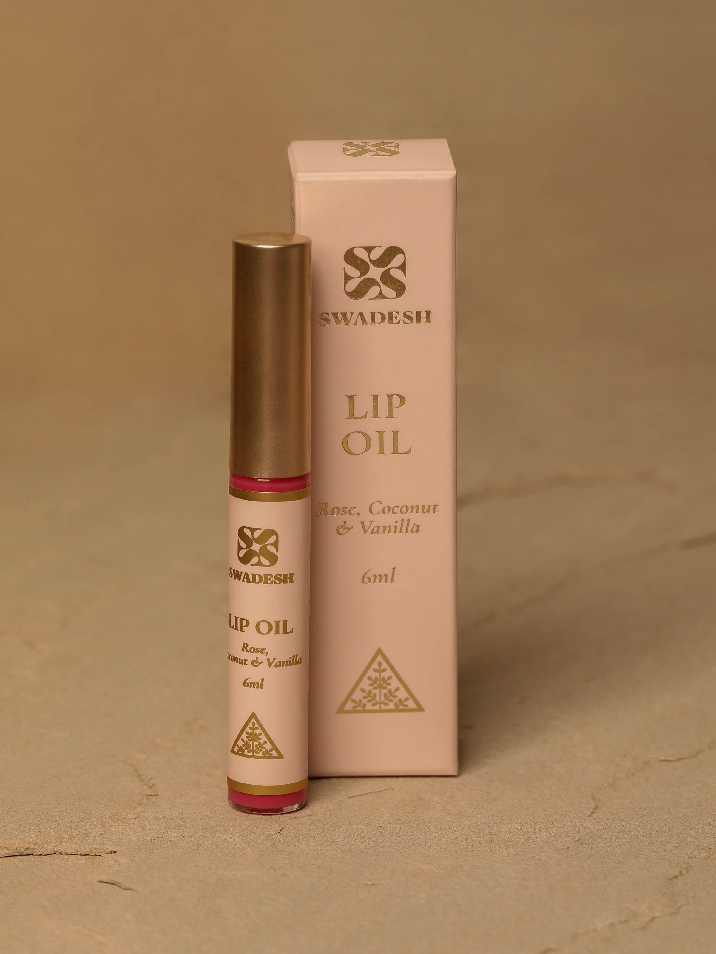 Lip Oil Rose, Coconut & Vanilla displayed with fresh flowers, highlighting its aromatic appeal