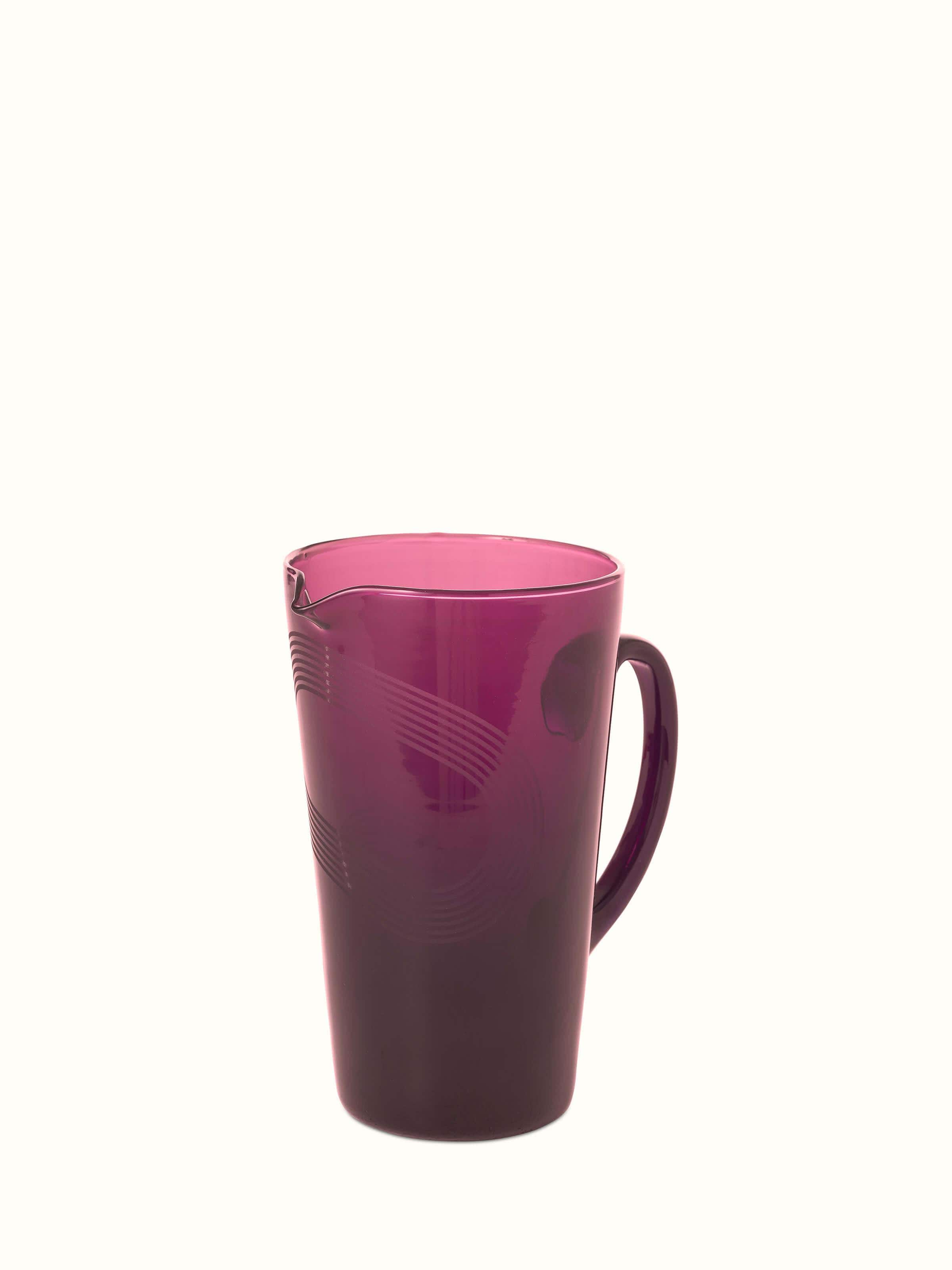 Angled view of Firozabadi glass pitcher in purple emphasizing its stylish spout and handle.