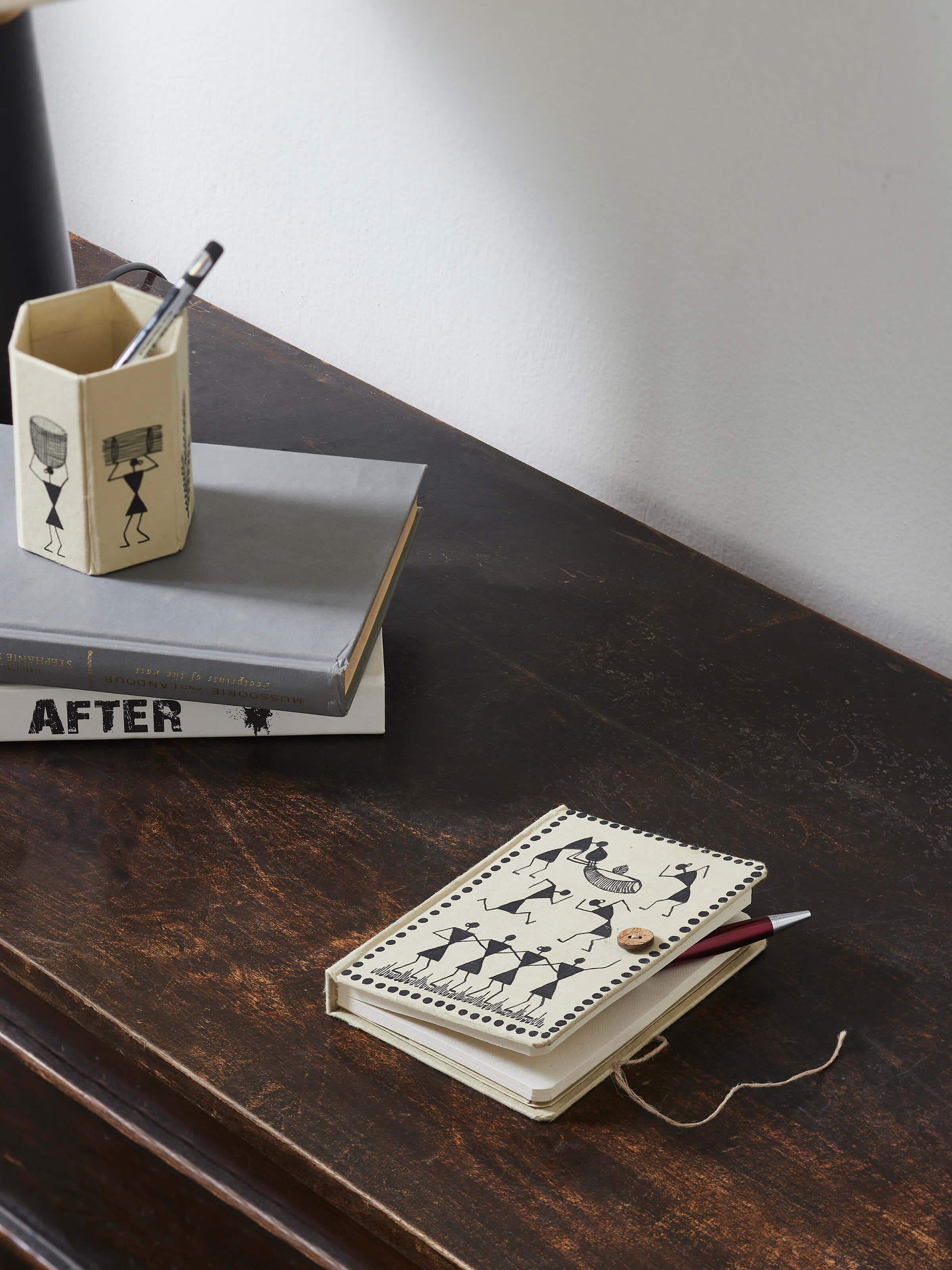 Side view of Warli painted paper journal in brown highlighting its slim profile and handcrafted design