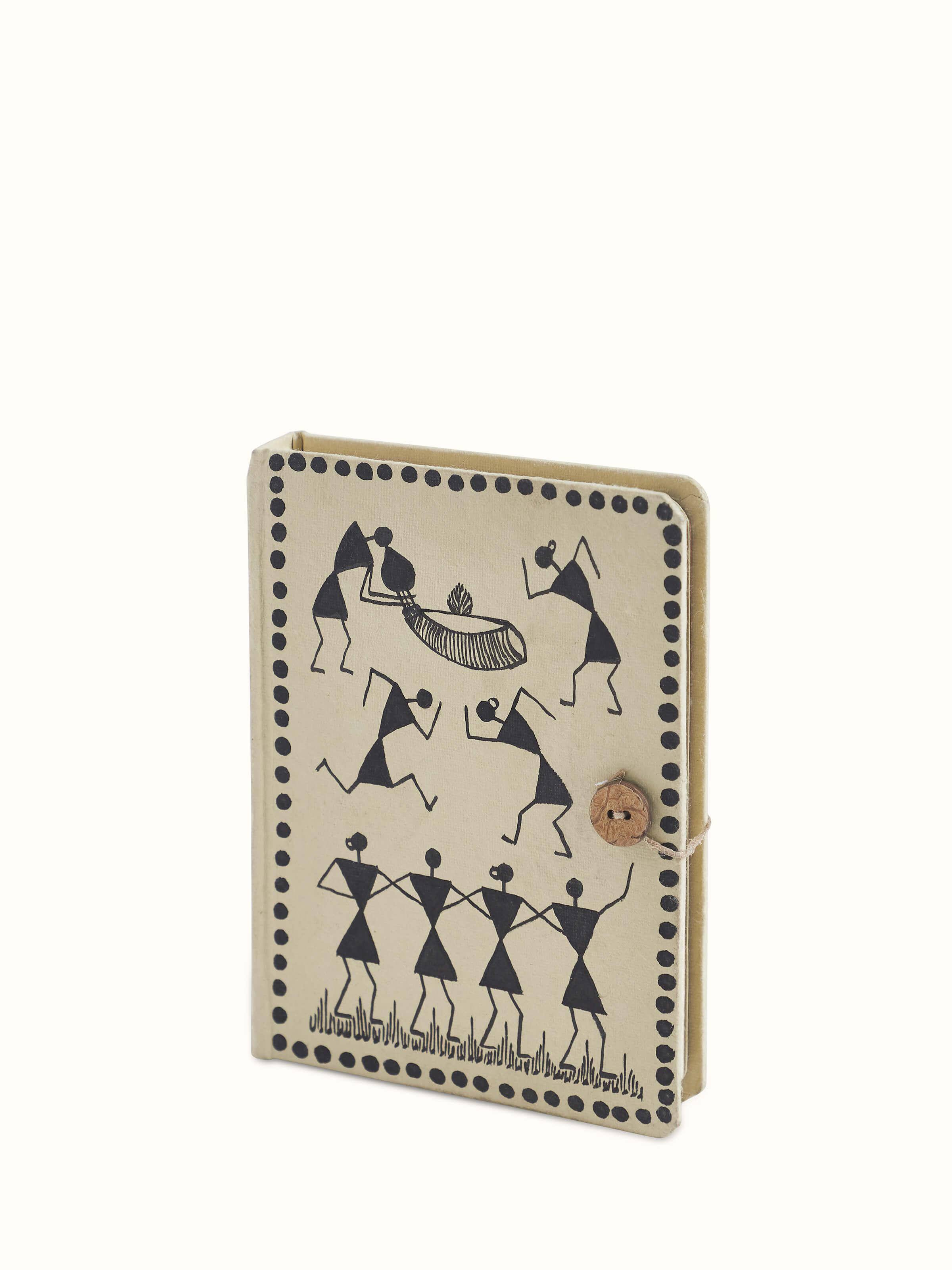 Close-up of Warli painted paper journal in brown showing detailed Warli painting and artistic elements