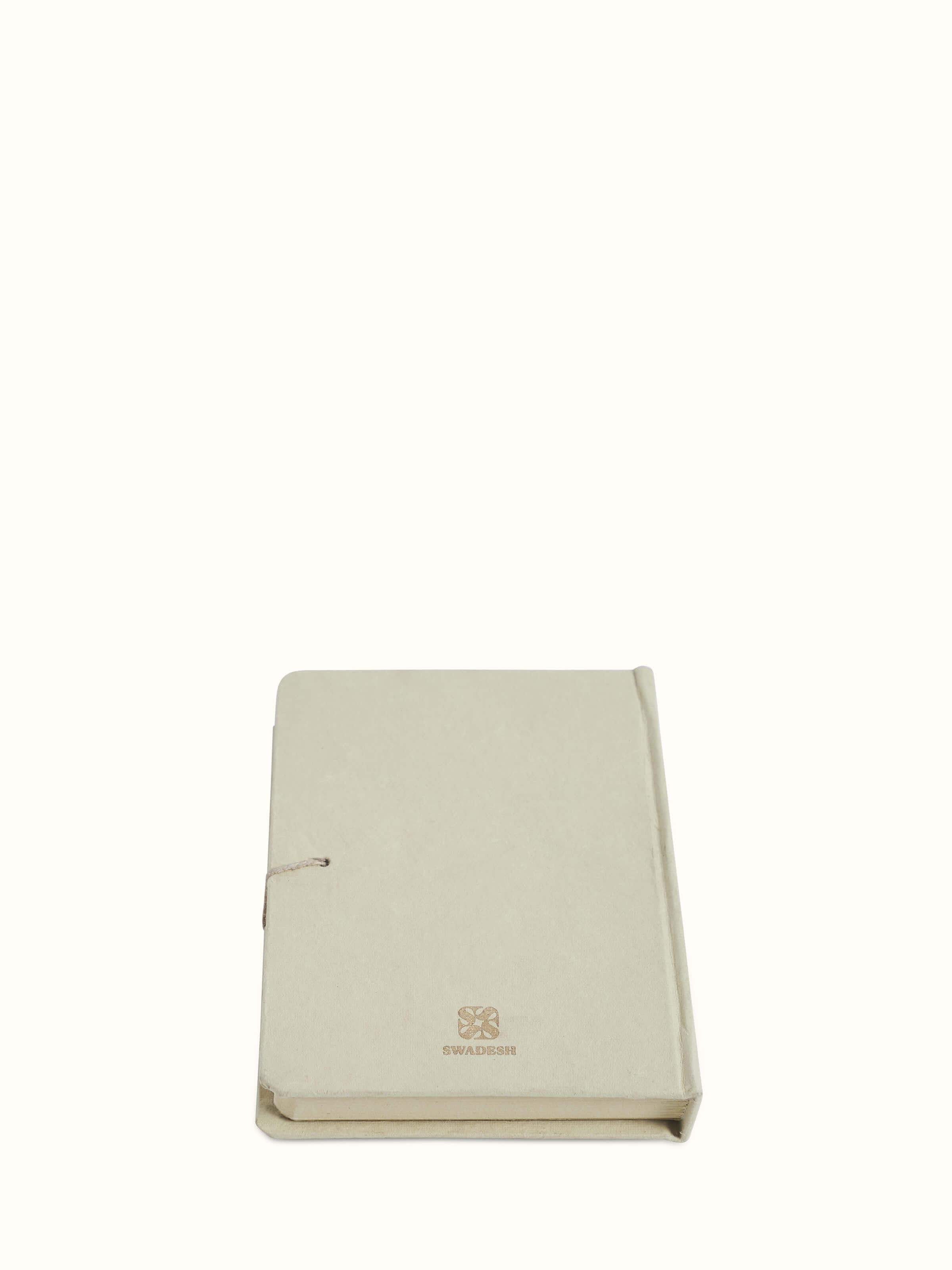 Angle view of Warli painted paper journal in brown emphasizing the craftsmanship and intricate Warli designs