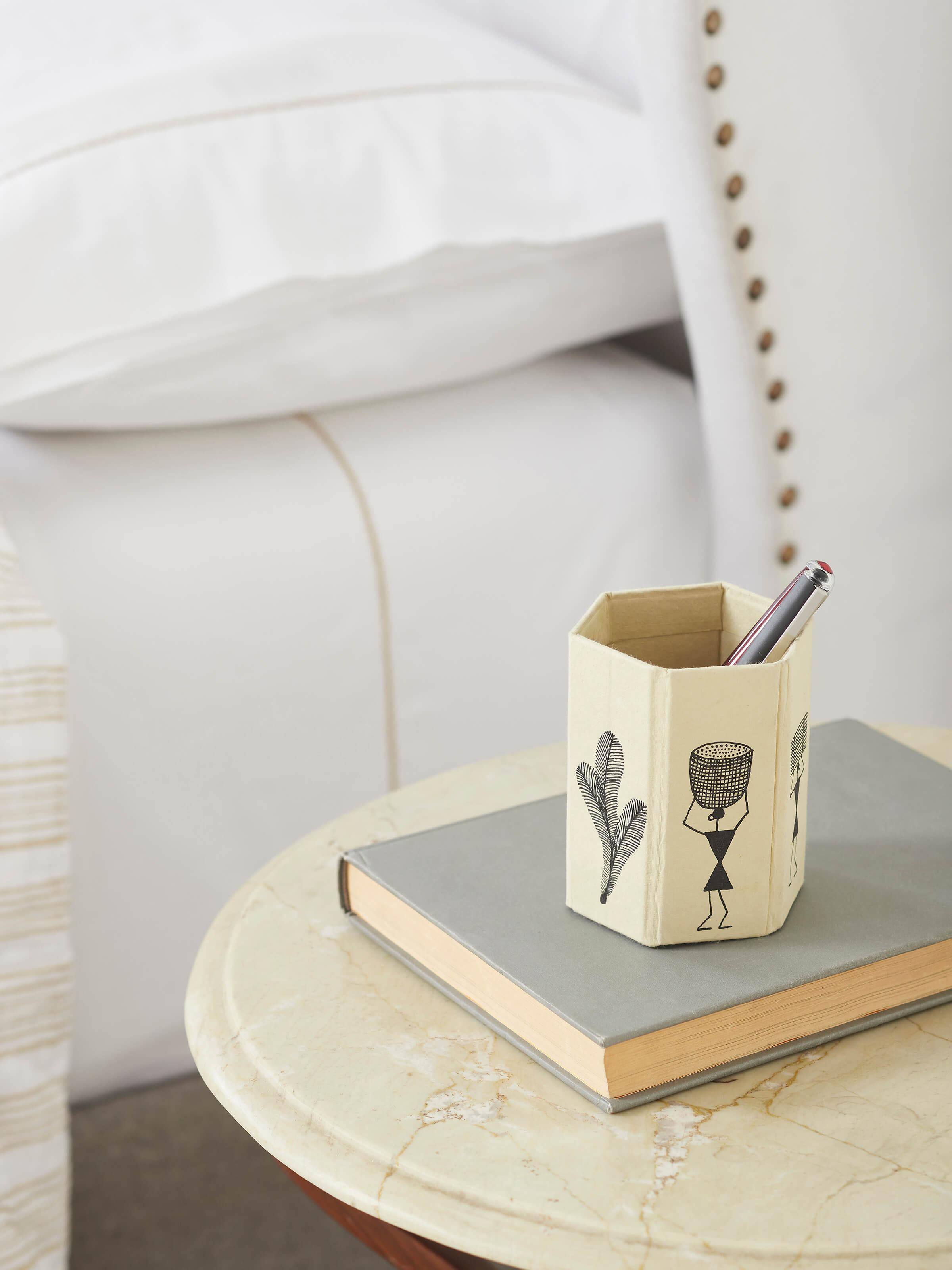 Side view of Warli Painted Paper Pen Stand in brown, highlighting the intricate Warli designs and craftsmanship