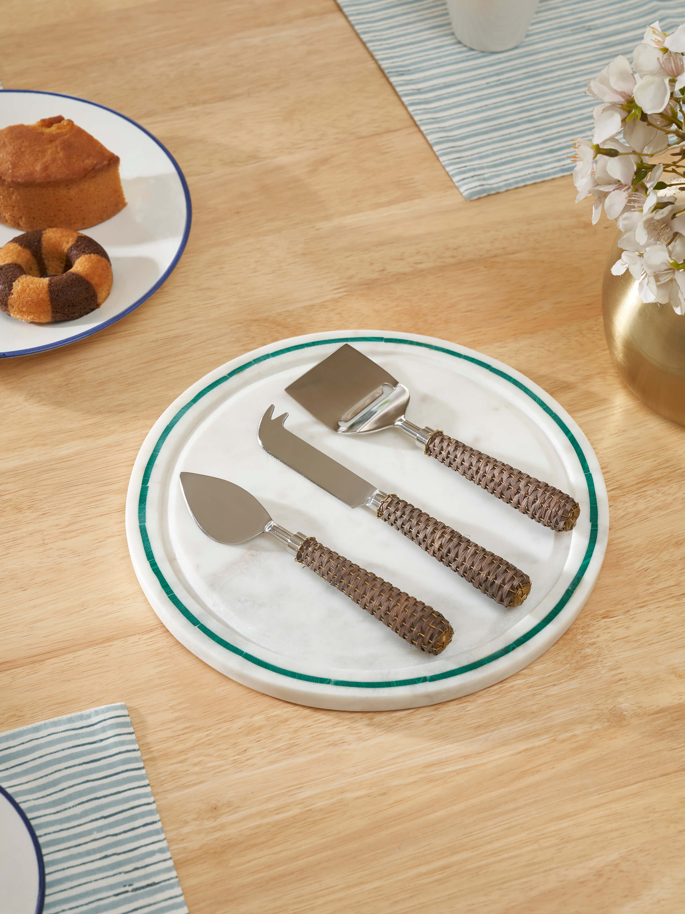 Close-up view of the stainless steel cheese knives with rattan handles, showcasing the elegant design and craftsmanship.