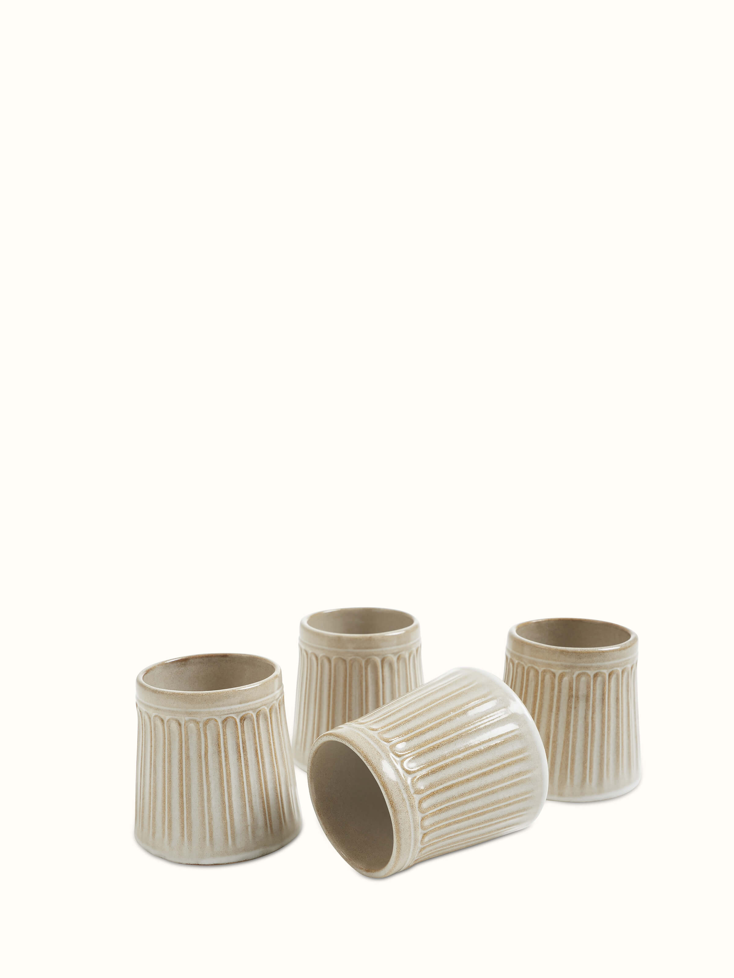 Detailed view of beige studio pottery ceramic water tumblers, emphasizing the craftsmanship.