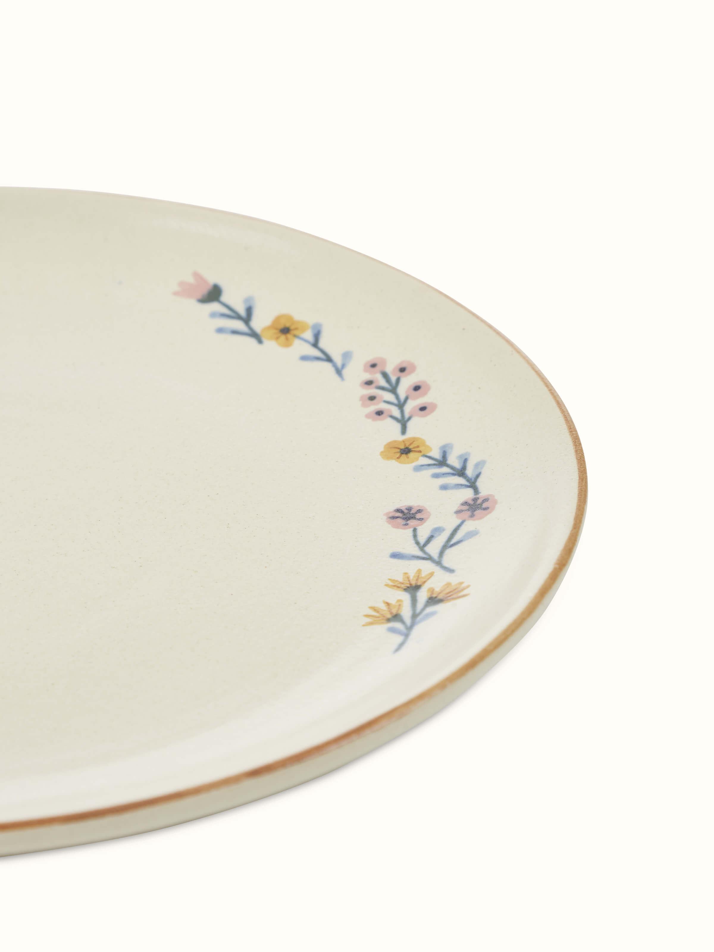 Close-up of beige studio pottery ceramic dinner plates set of 4, focusing on the texture of the glaze
