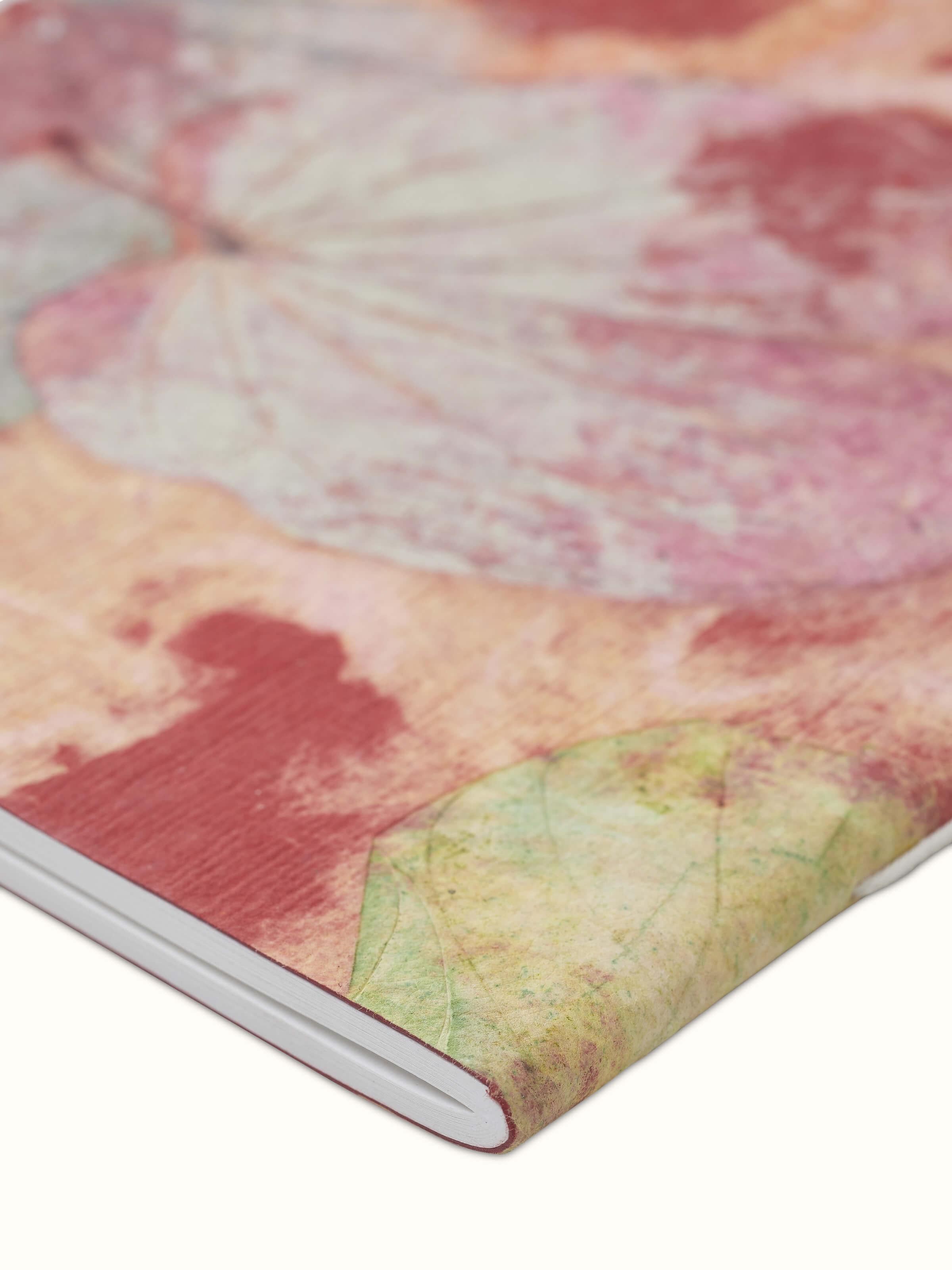 Detailed view of Auroville handmade paper notebook in orange highlighting the textured paper and artisanal touch.