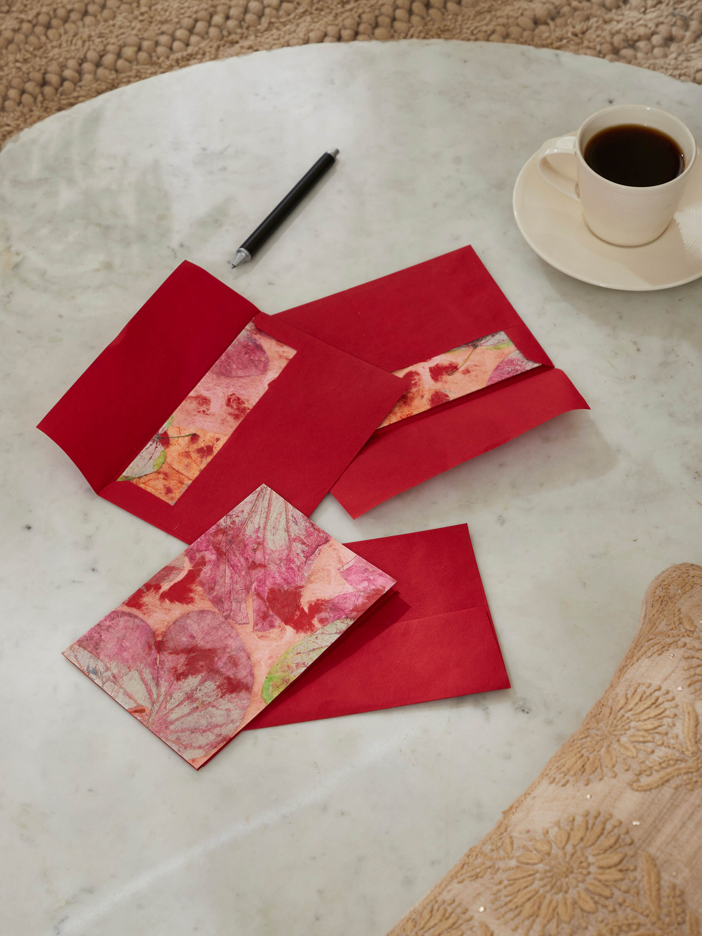 Side view of Auroville handmade paper money envelopes in red, highlighting the quality of handmade paper and elegant design