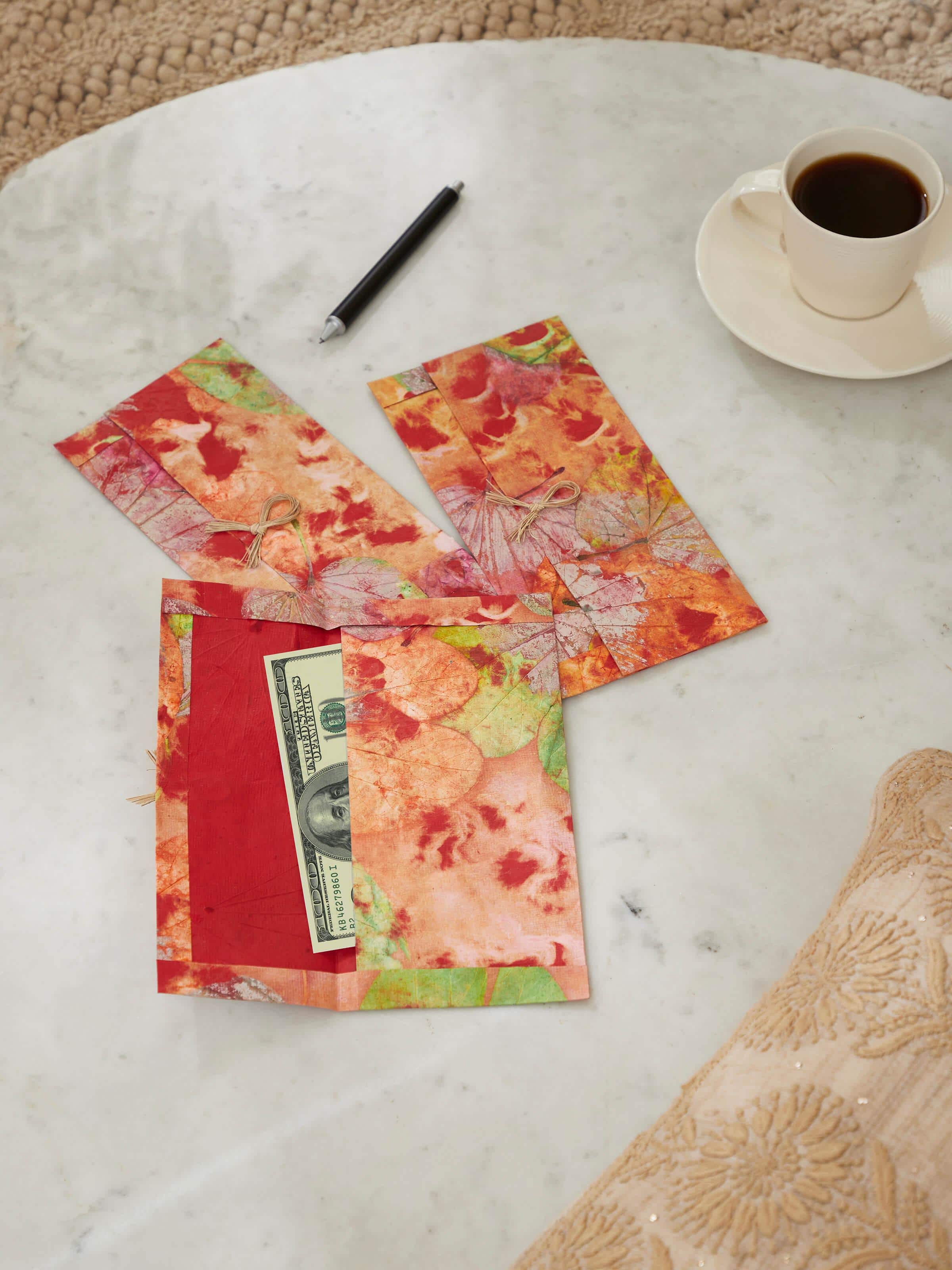 Side view of Auroville handmade paper money envelopes in orange, set of 3, showcasing the detailed design and craftsmanship.