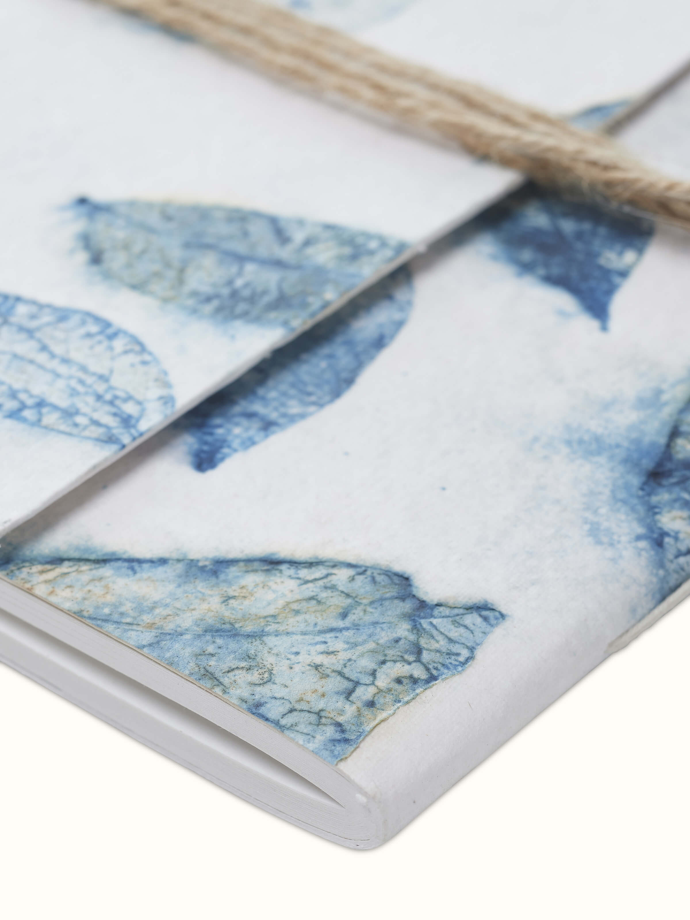 Close-up view of Auroville handmade paper notebook with blue rope binding, showcasing the texture