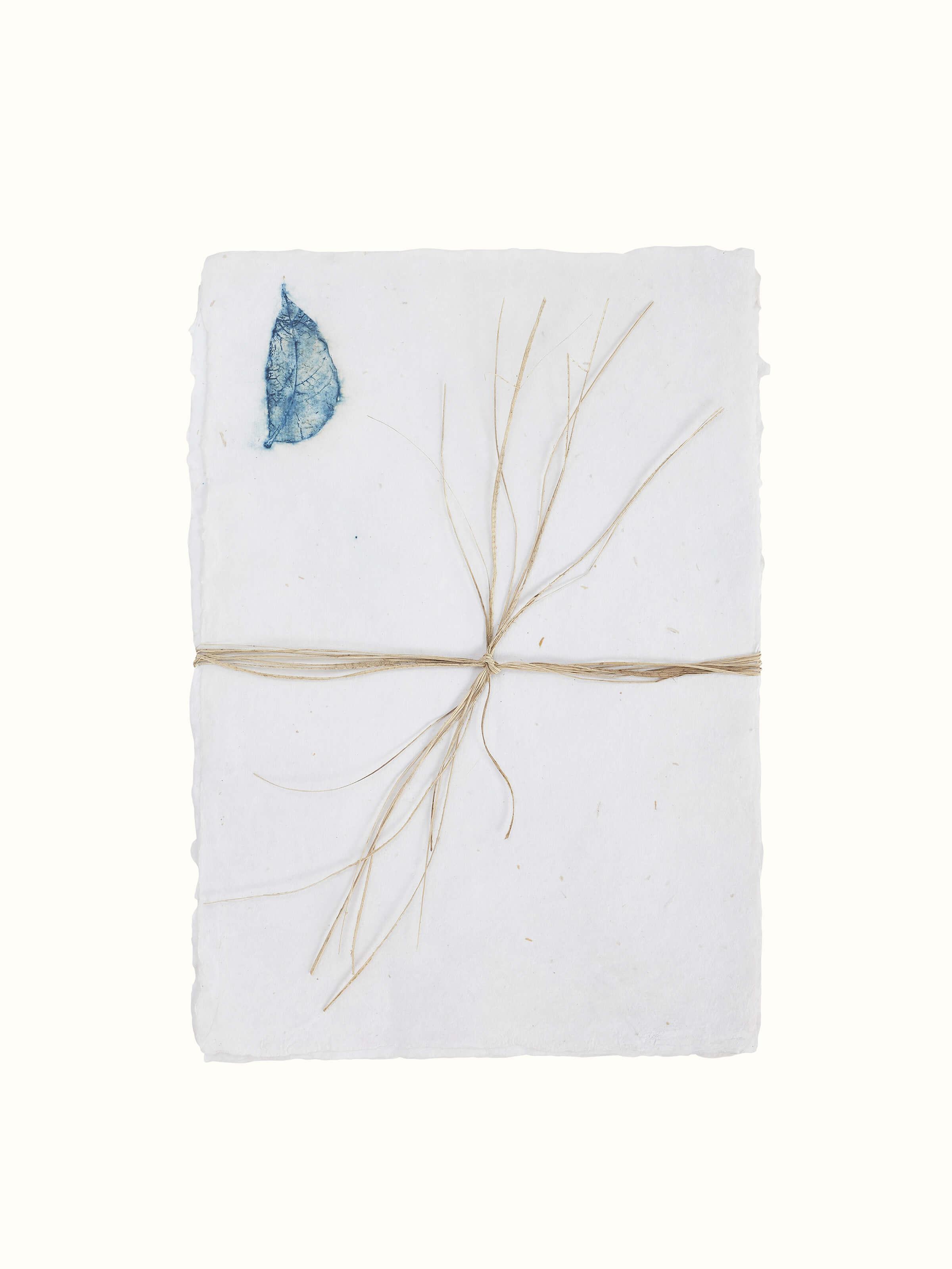 Detailed view of Auroville handmade paper sheets in white, showing their quality and composition.