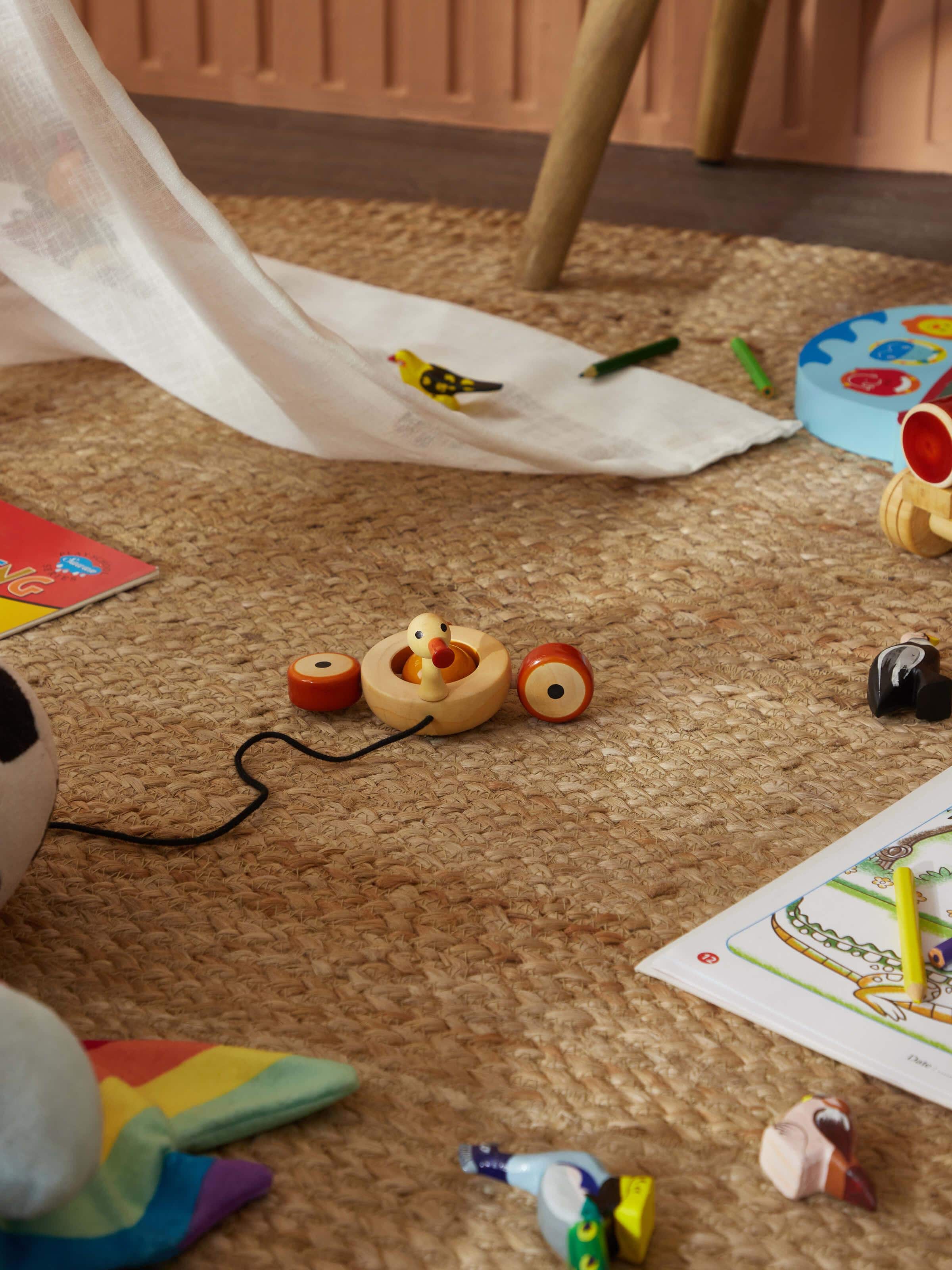 Side view of Channapatna Ivory Wood Duby Duck Toy, showing the shape and subtle color tones of the toy