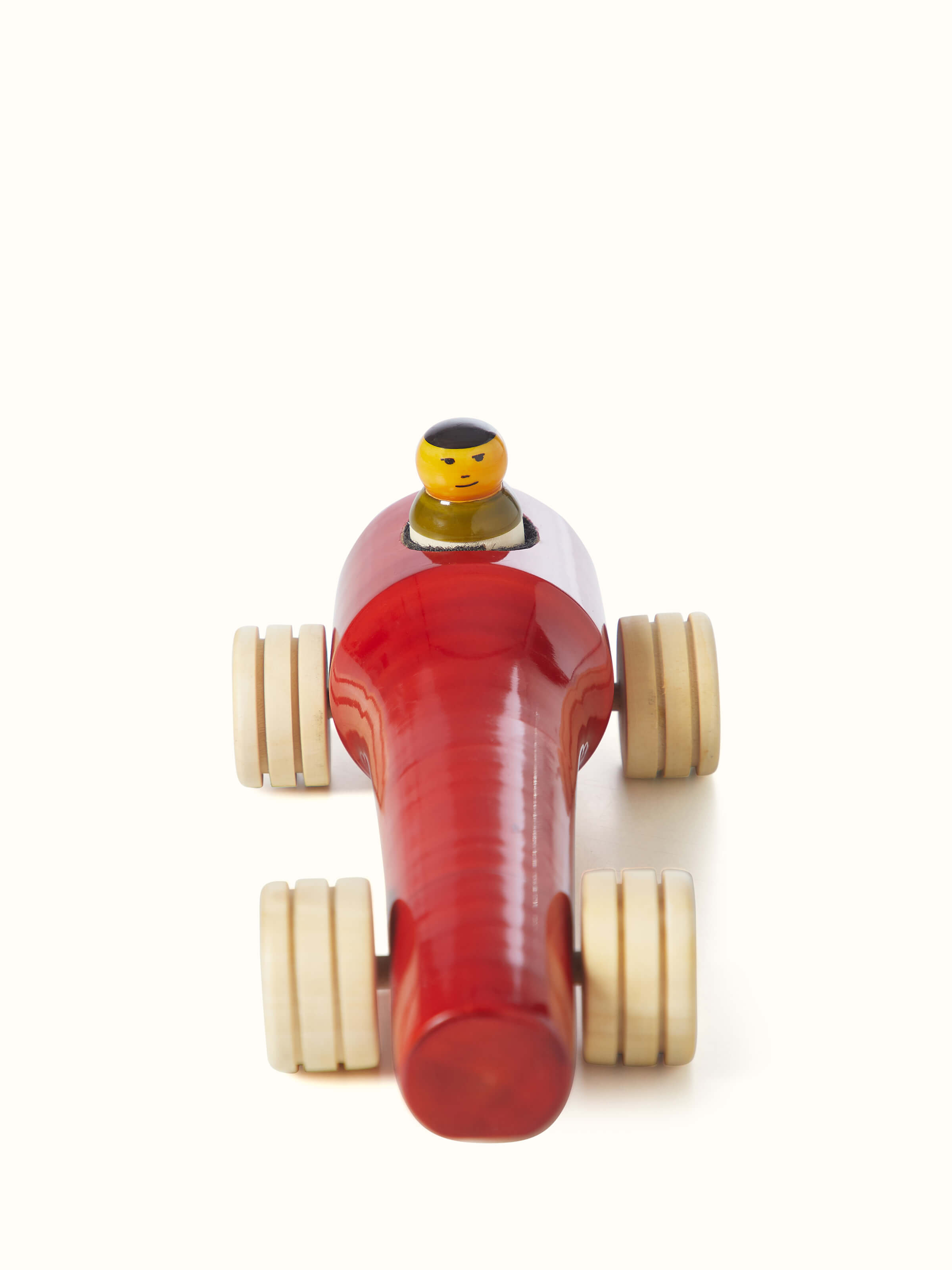 Channapatna ivory wood vroom toy in red, showcasing the smooth finish and detailed design.