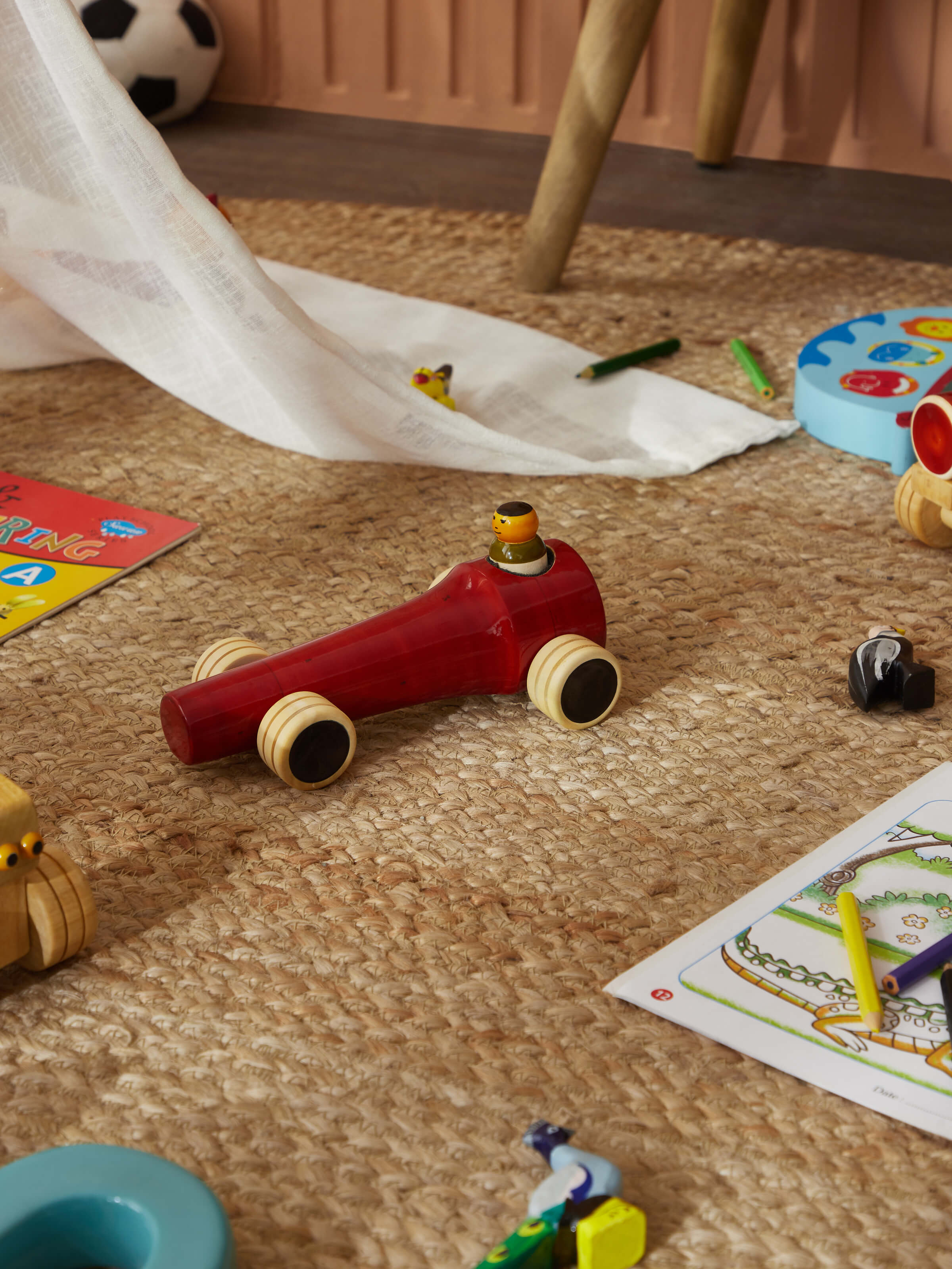Side view of Channapatna ivory wood vroom toy in red highlighting its craftsmanship and design.