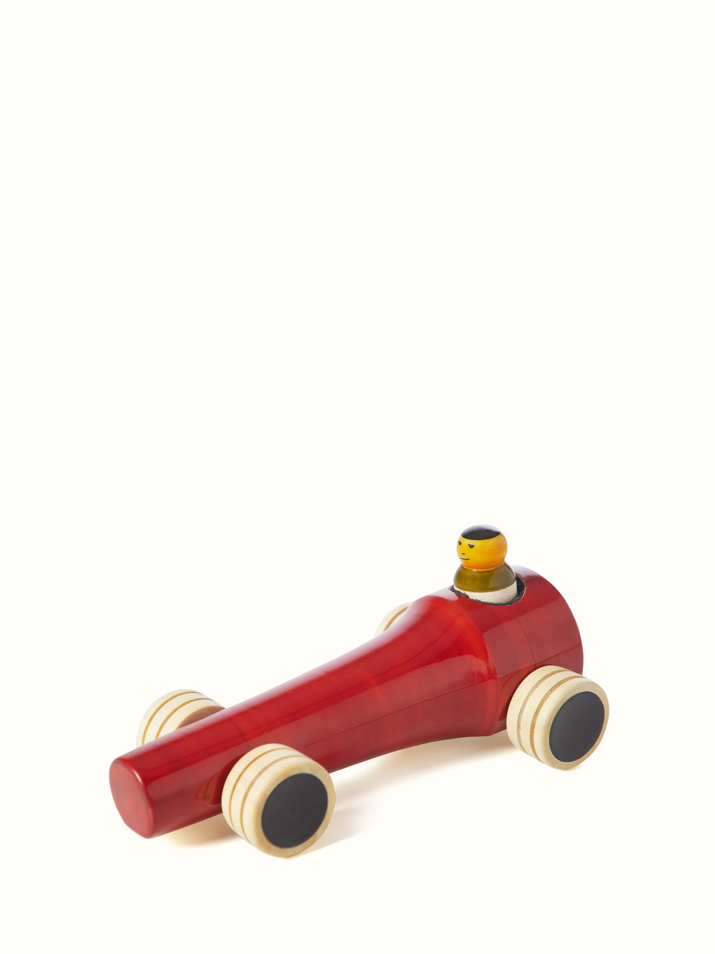 Detailed view of Channapatna ivory wood vroom toy in red focusing on the toy’s texture and color.
