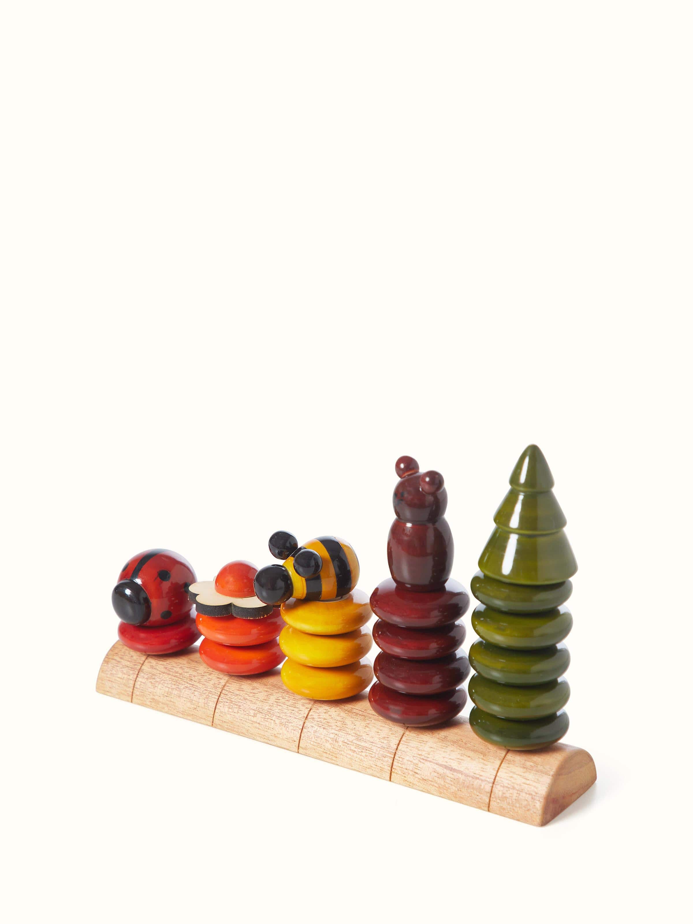 Artistic view of Channapatna ivory wood peppy five educational toy set, showcasing its vibrant colors.