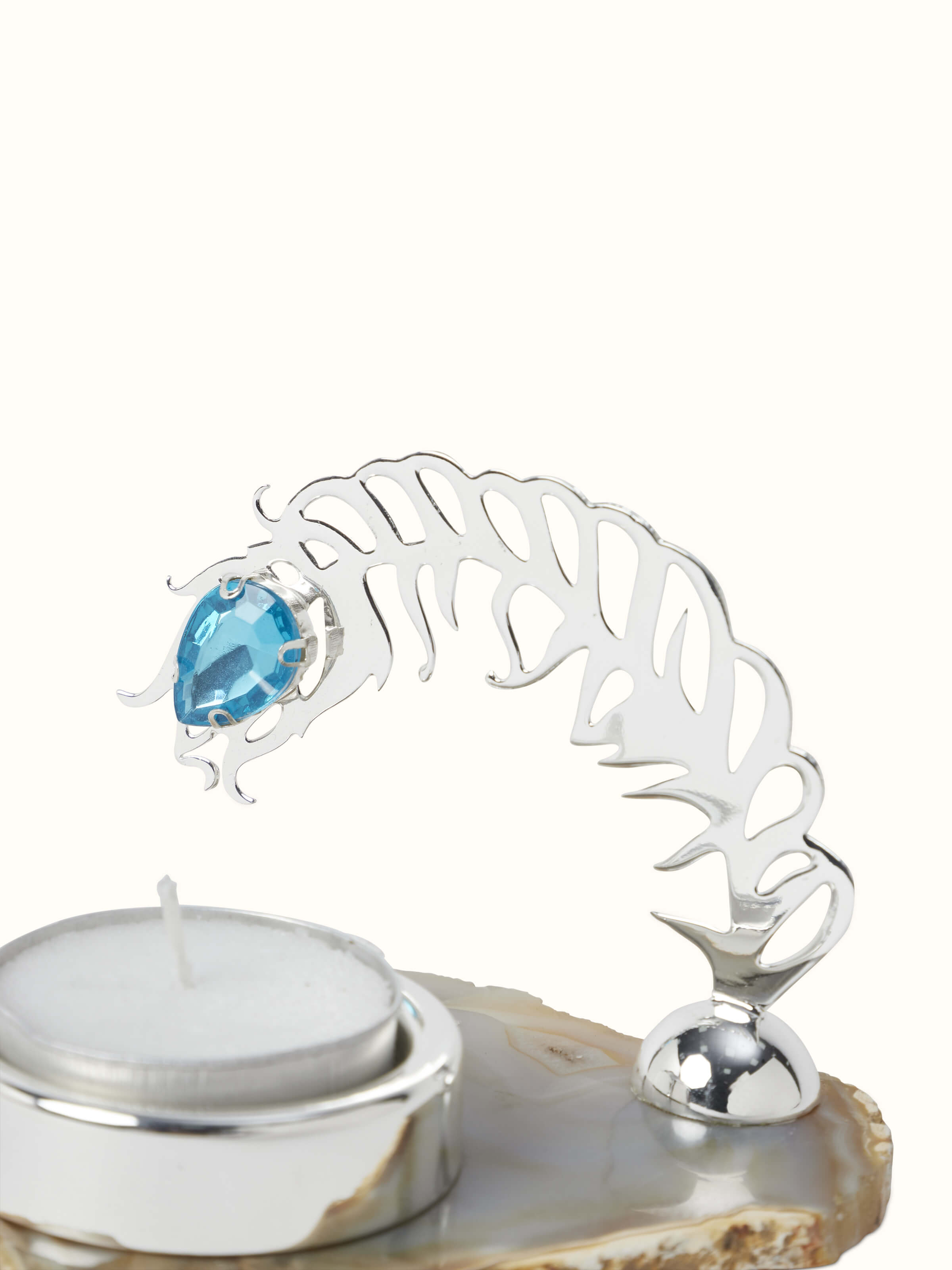 Side view of Silver-plated peacock feather tea light holder highlighting the blue gemstone and intricate details