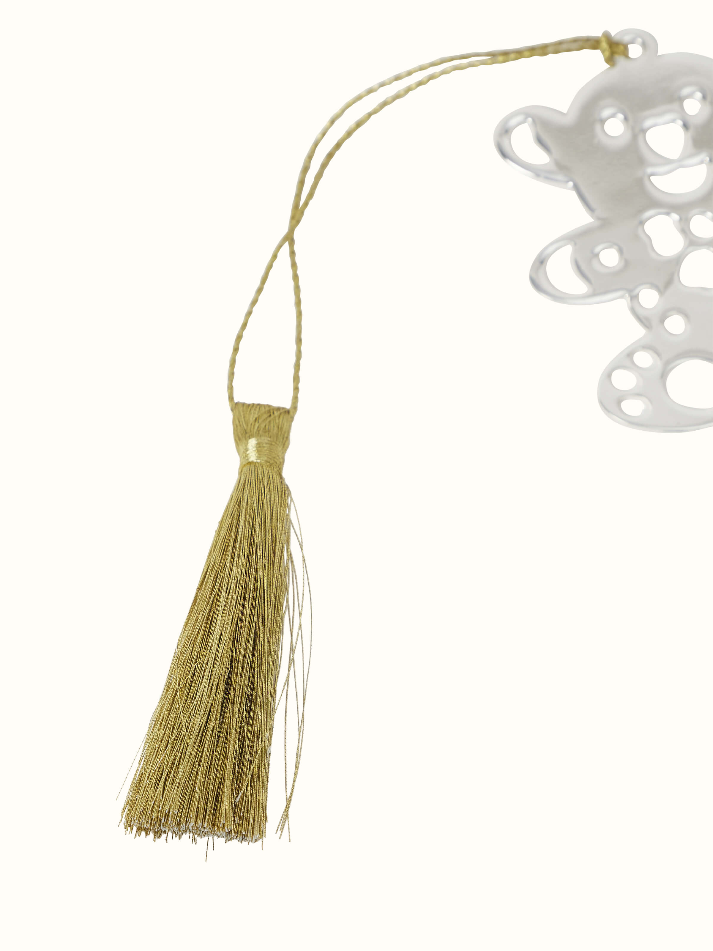 Close-up of silver-plated teddy bookmark focusing on its shiny surface and charming design