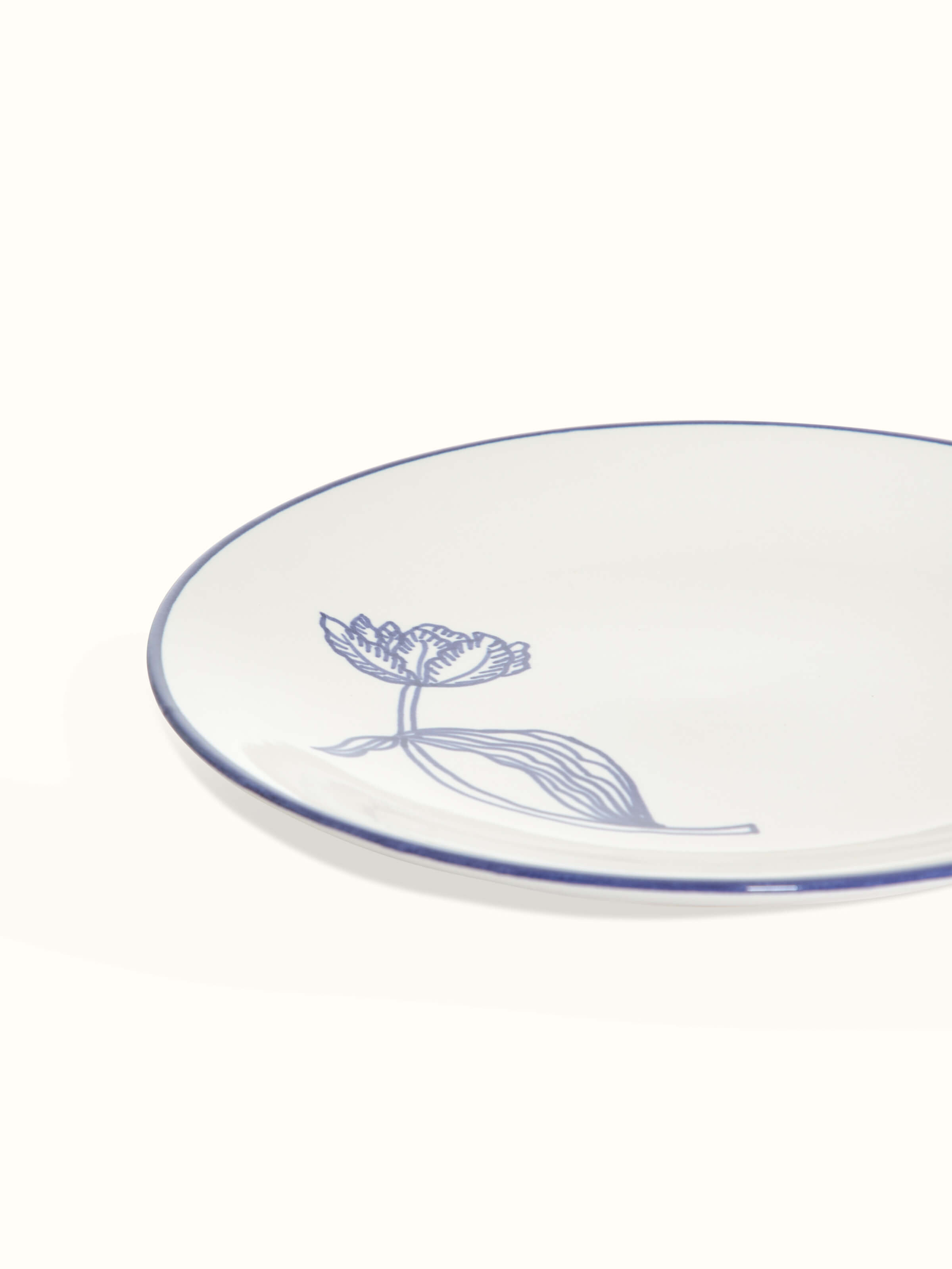 Close-up of white and blue Khurja pottery ceramic dinner plates, focusing on the intricate blue patterns and white ceramic base.