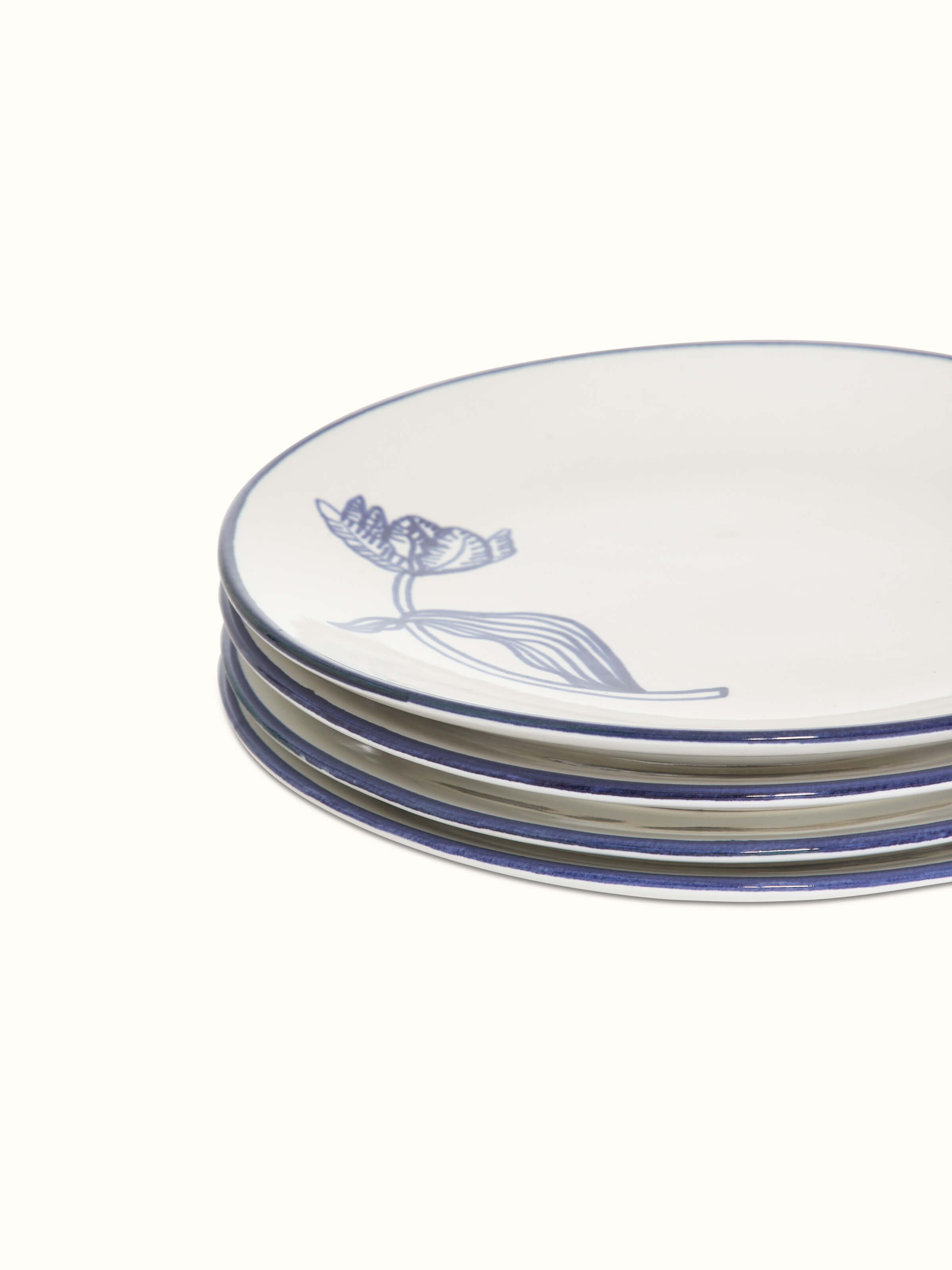 Close-up of the edge of white and blue Khurja pottery ceramic dinner plates, highlighting the detailed rim design.