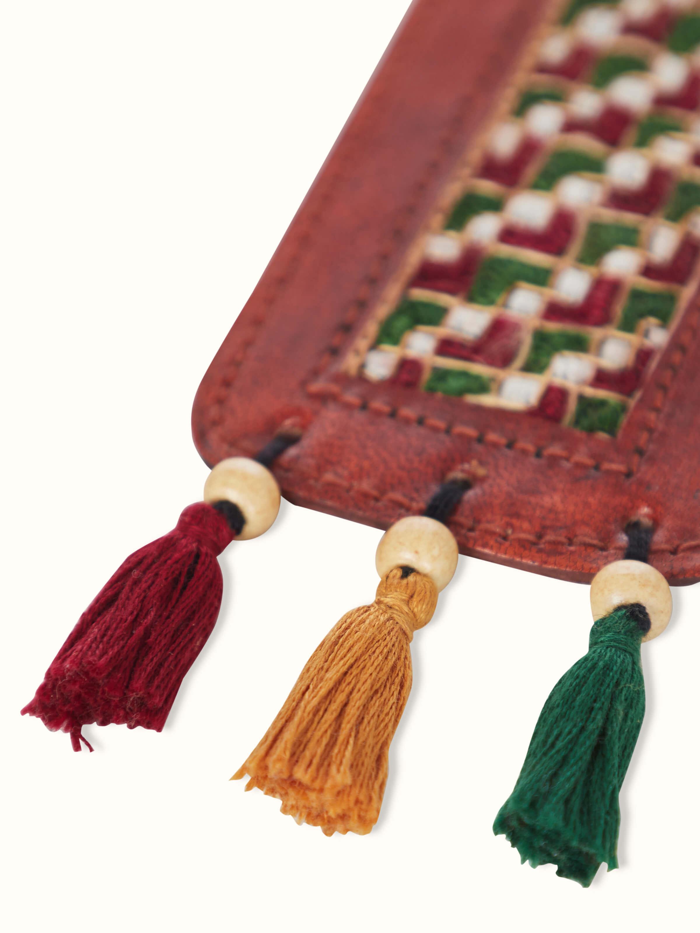 Artistic view of Kutch embroidery leather bookmark in red, emphasizing the design.