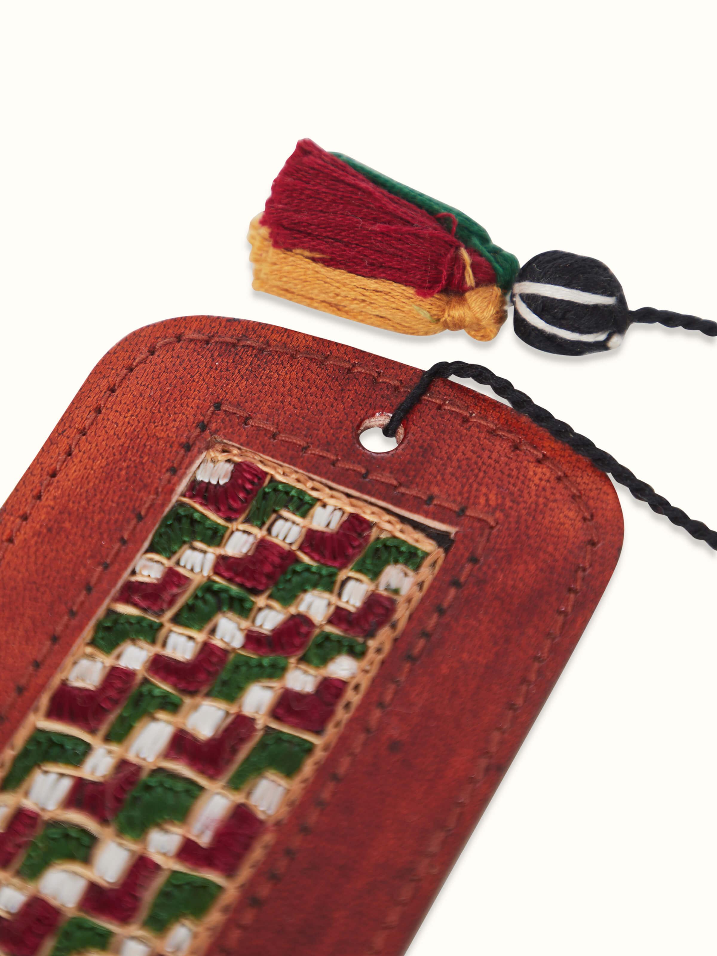 Detailed view of Kutch embroidery leather bookmark in red, showcasing the craftsmanship.