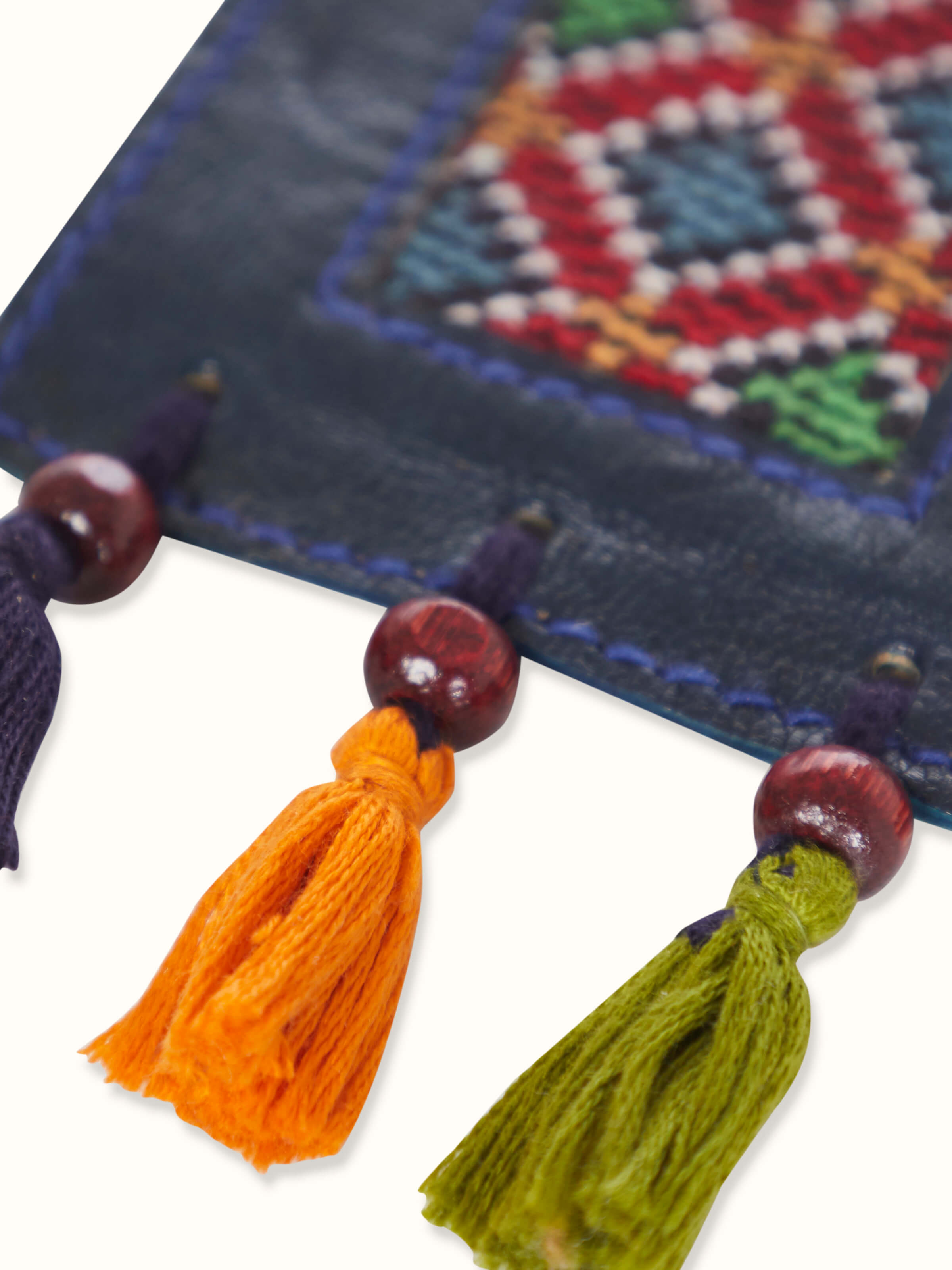 Angled view of blue Kutch embroidery leather bookmark, emphasizing the vibrant color and detailed embroidery.