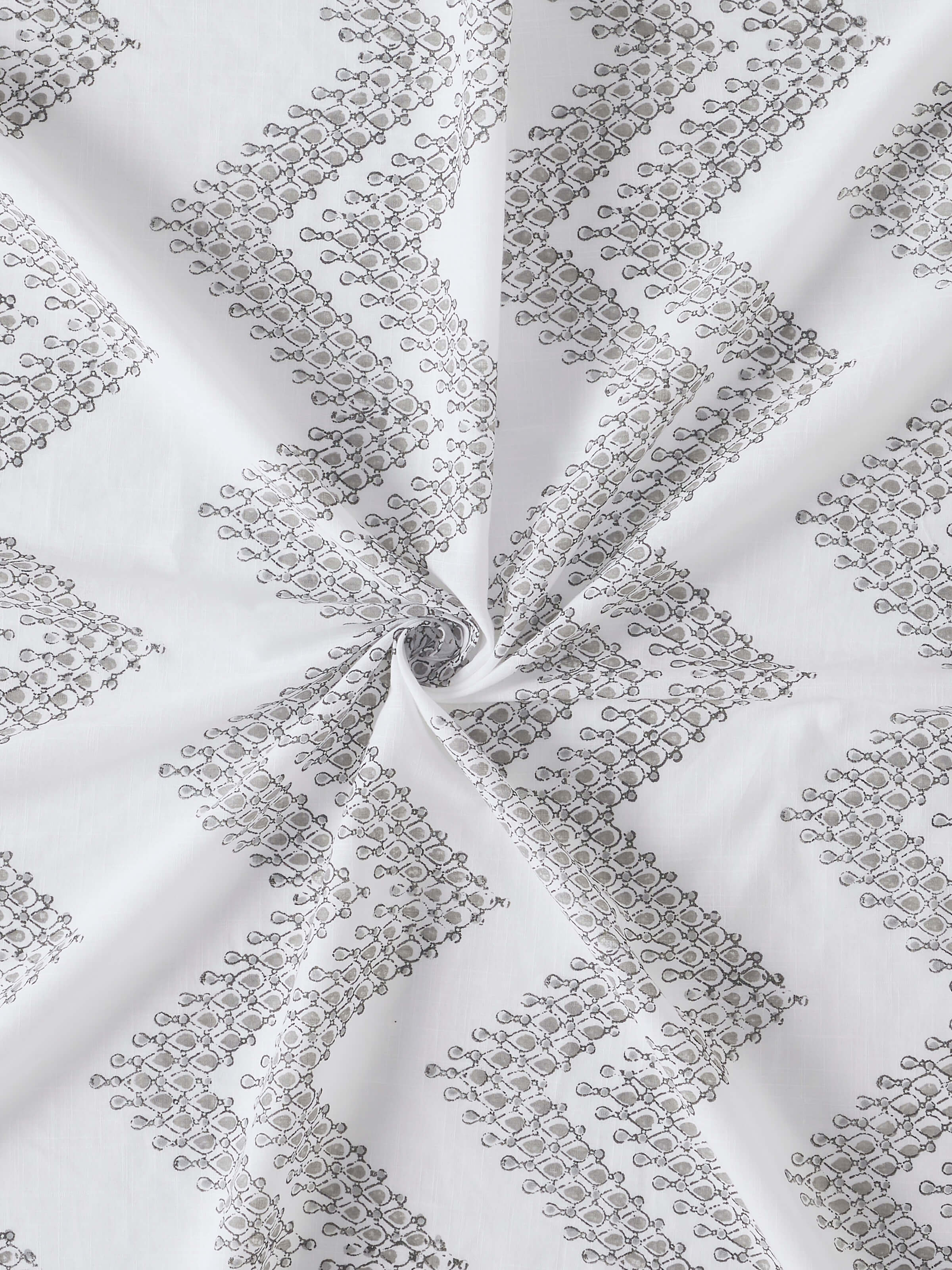 Full view of Rambagh white modern geo chevron cotton Sanganeri block printed curtain (7 ft) hung on a curtain rod, showcasing its elegant look.