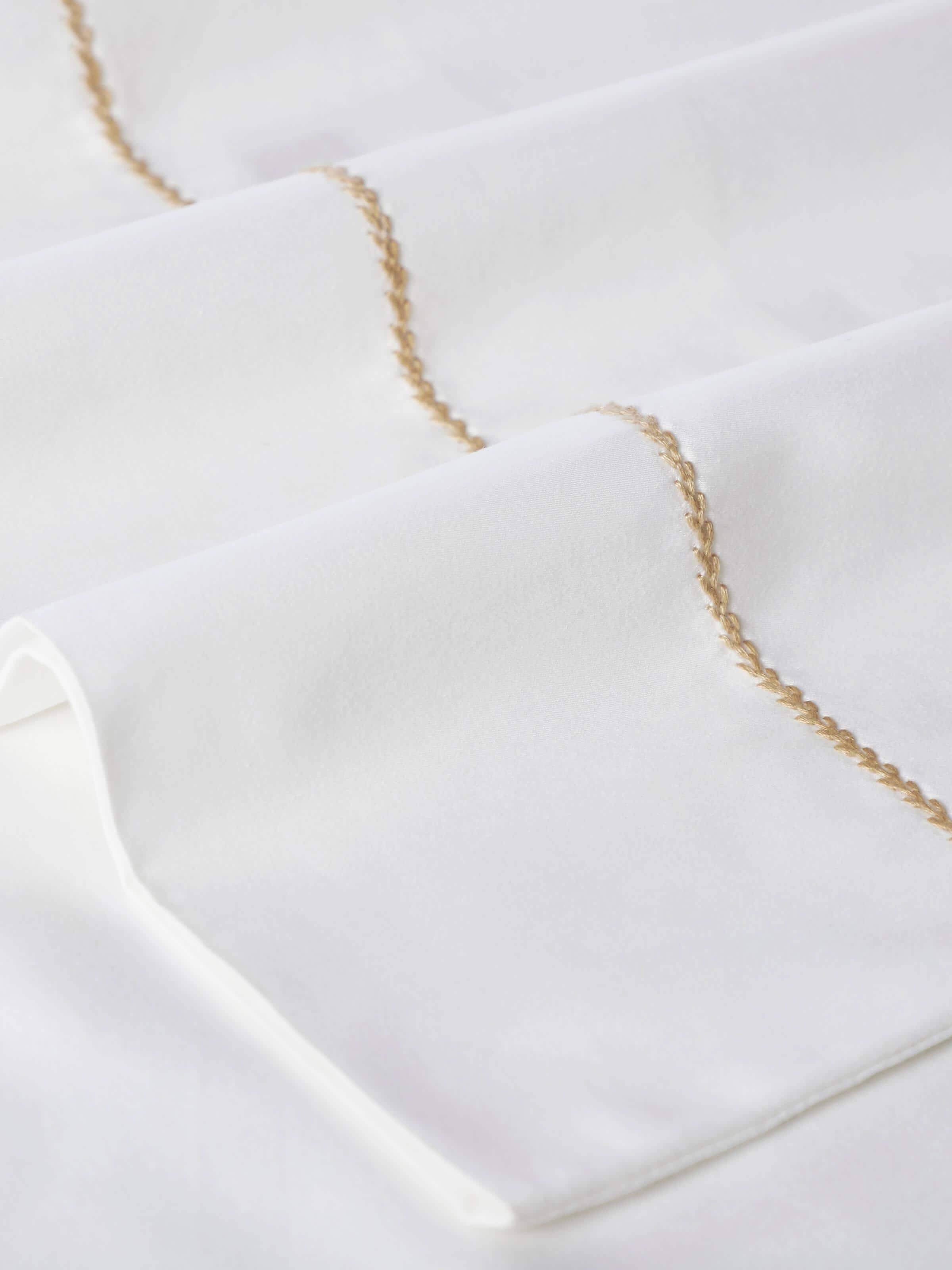 Shivranjini beige stripe cotton hand embroidered bedsheet king set displayed on a bed, showcasing its design and use in a bedroom setting.