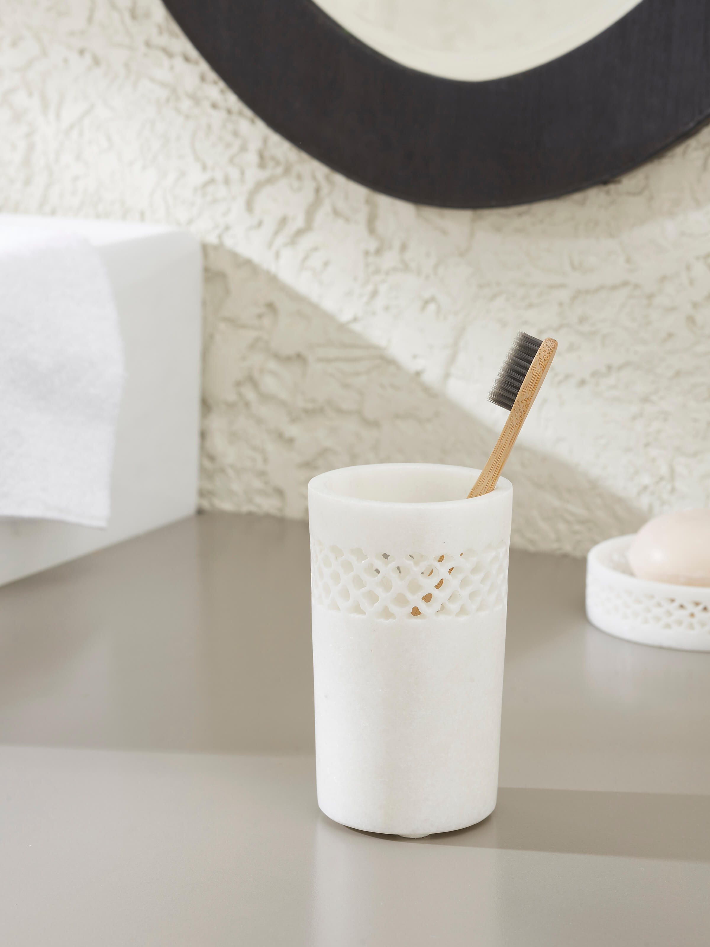 Side view of Carved Ambaji white marble toothbrush holder highlighting its detailed carvings and classic design