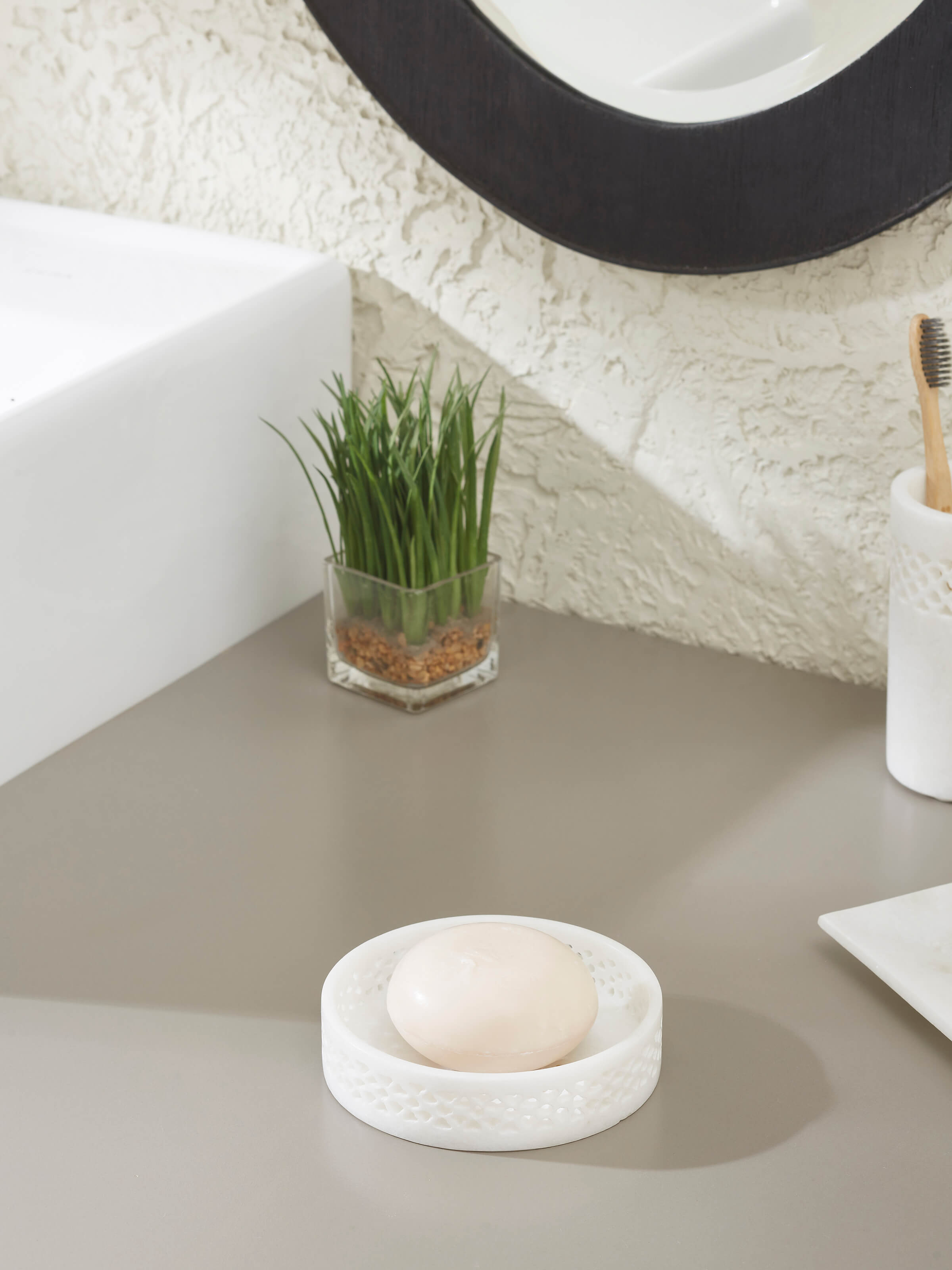 Close-up of carved Ambaji white marble soap dish, showcasing detailed carving and smooth surface.