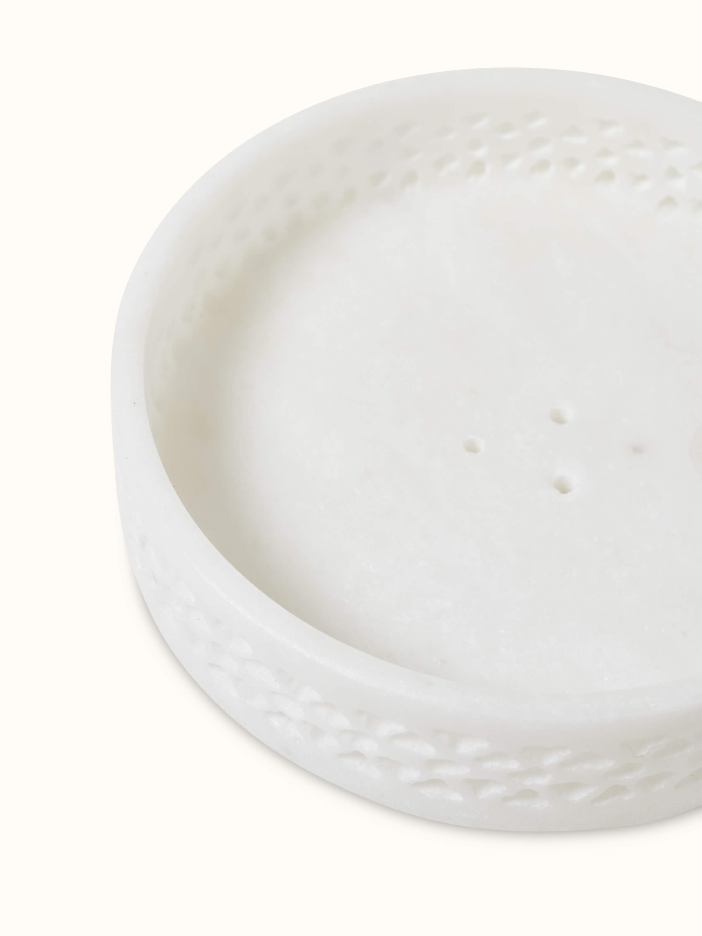 Angled view of carved Ambaji white marble soap dish, showing its delicate carvings and luxurious appearance.