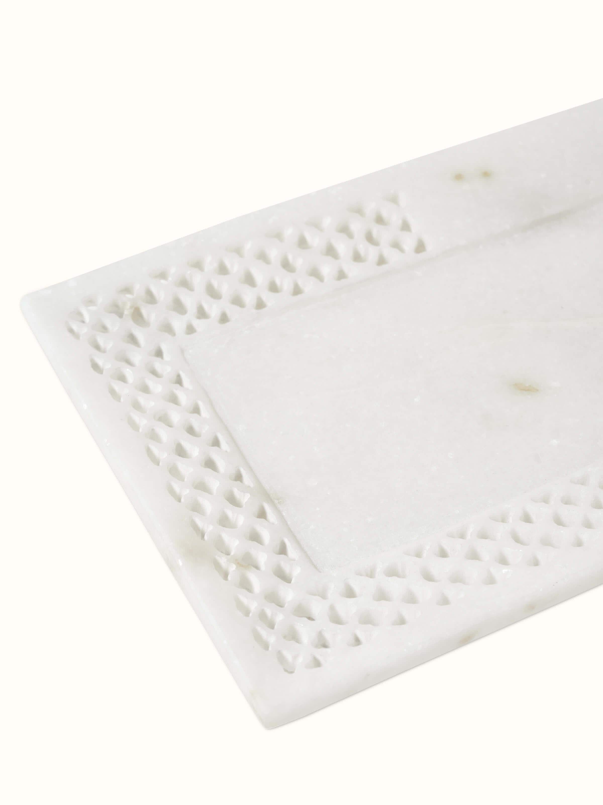 Close-up view of Carved Ambaji marble bath tray in white, highlighting intricate carvings and smooth texture.