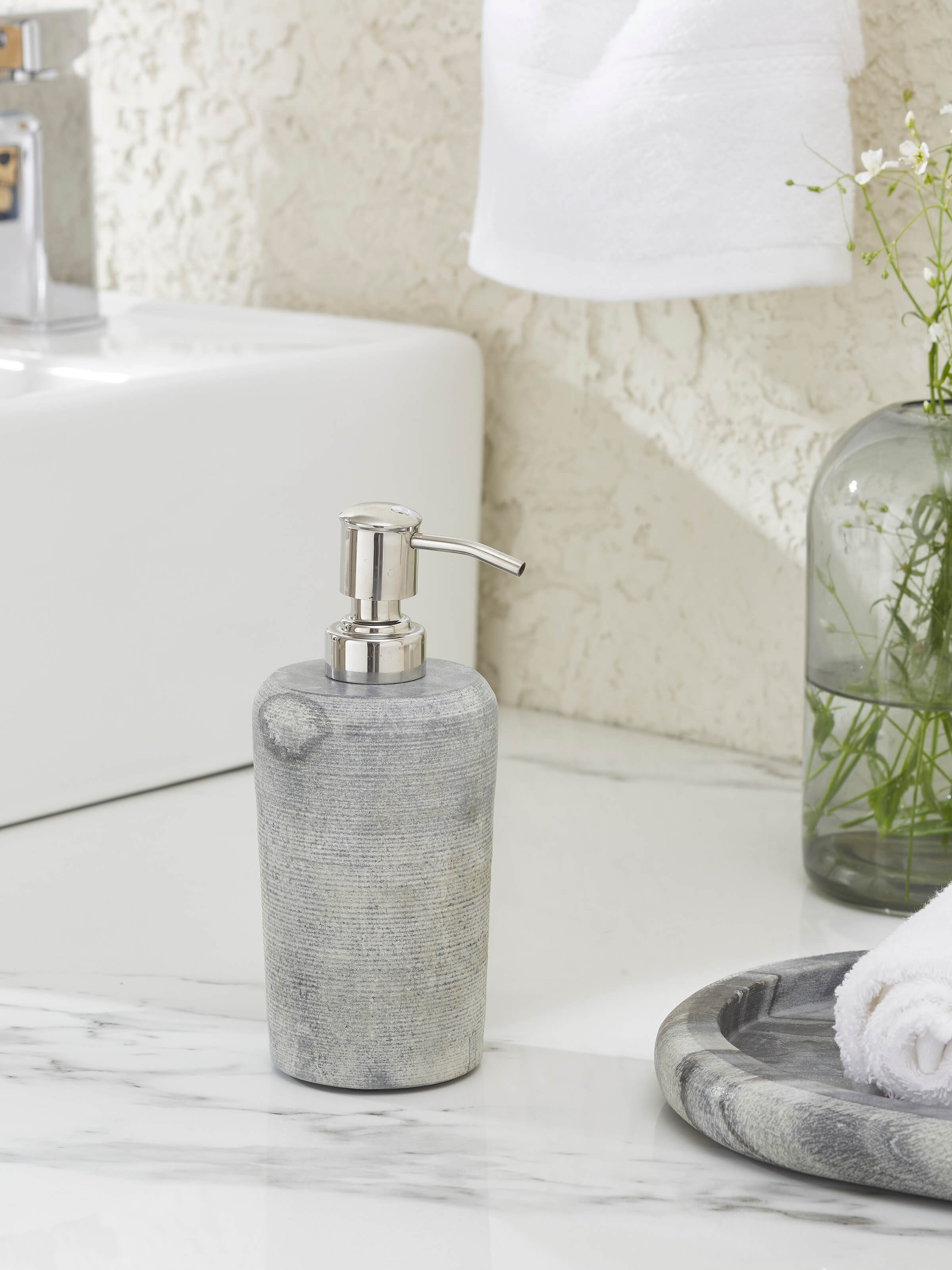 Side view of Carved Marble Soap Dispenser in grey color showcasing the dispenser's shape and details.