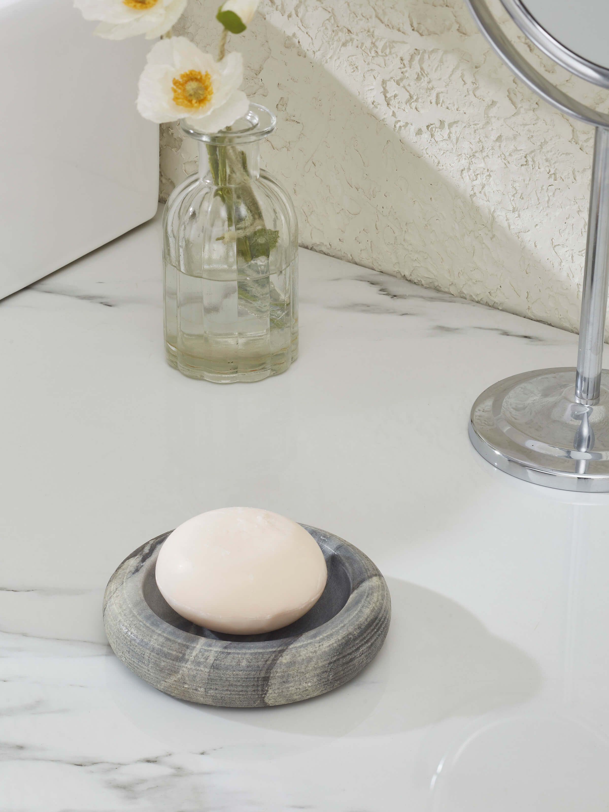 Side view of grey carved marble soap dish highlighting elegant design