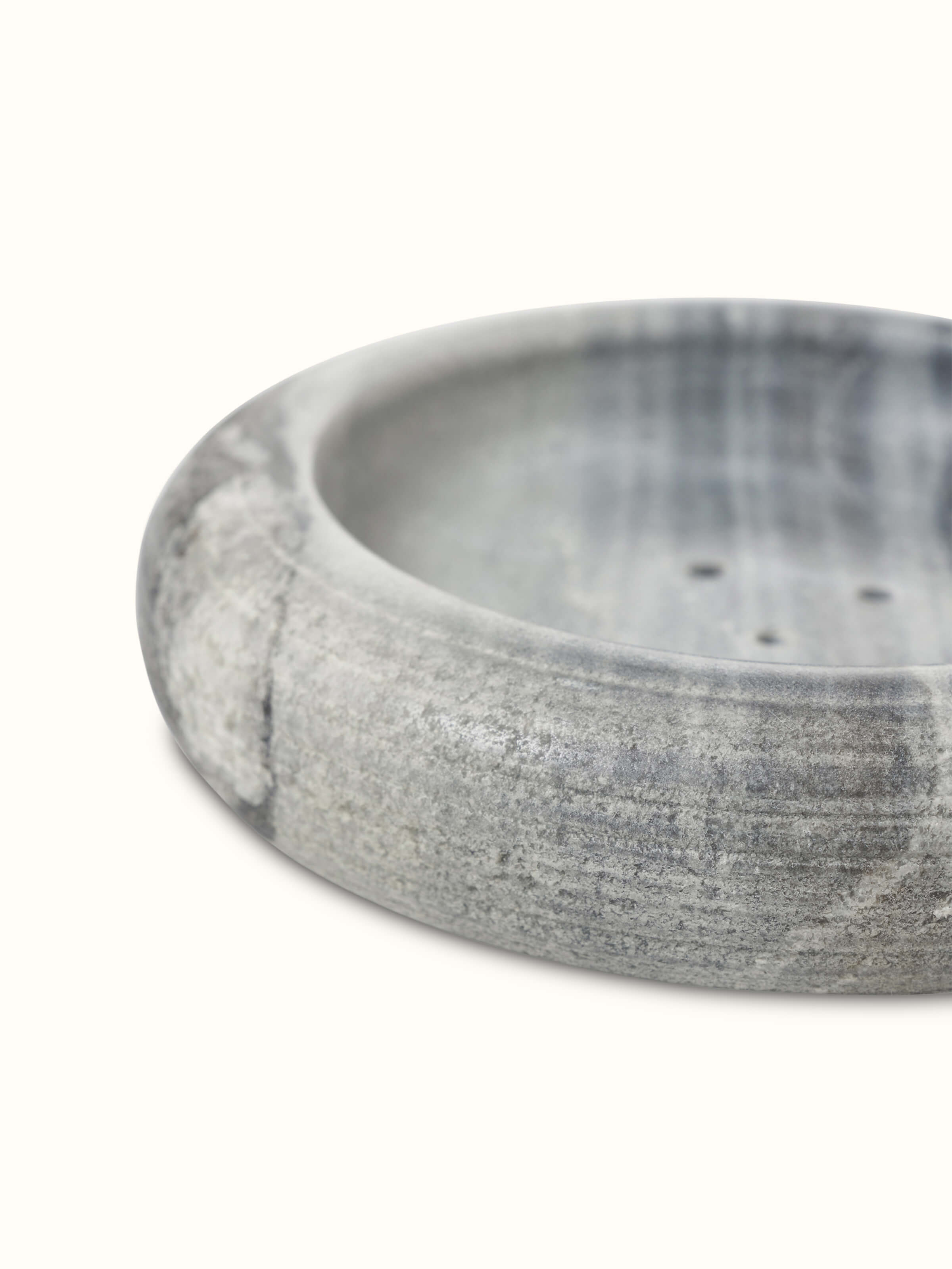 Close-up of grey carved marble soap dish showing intricate patterns