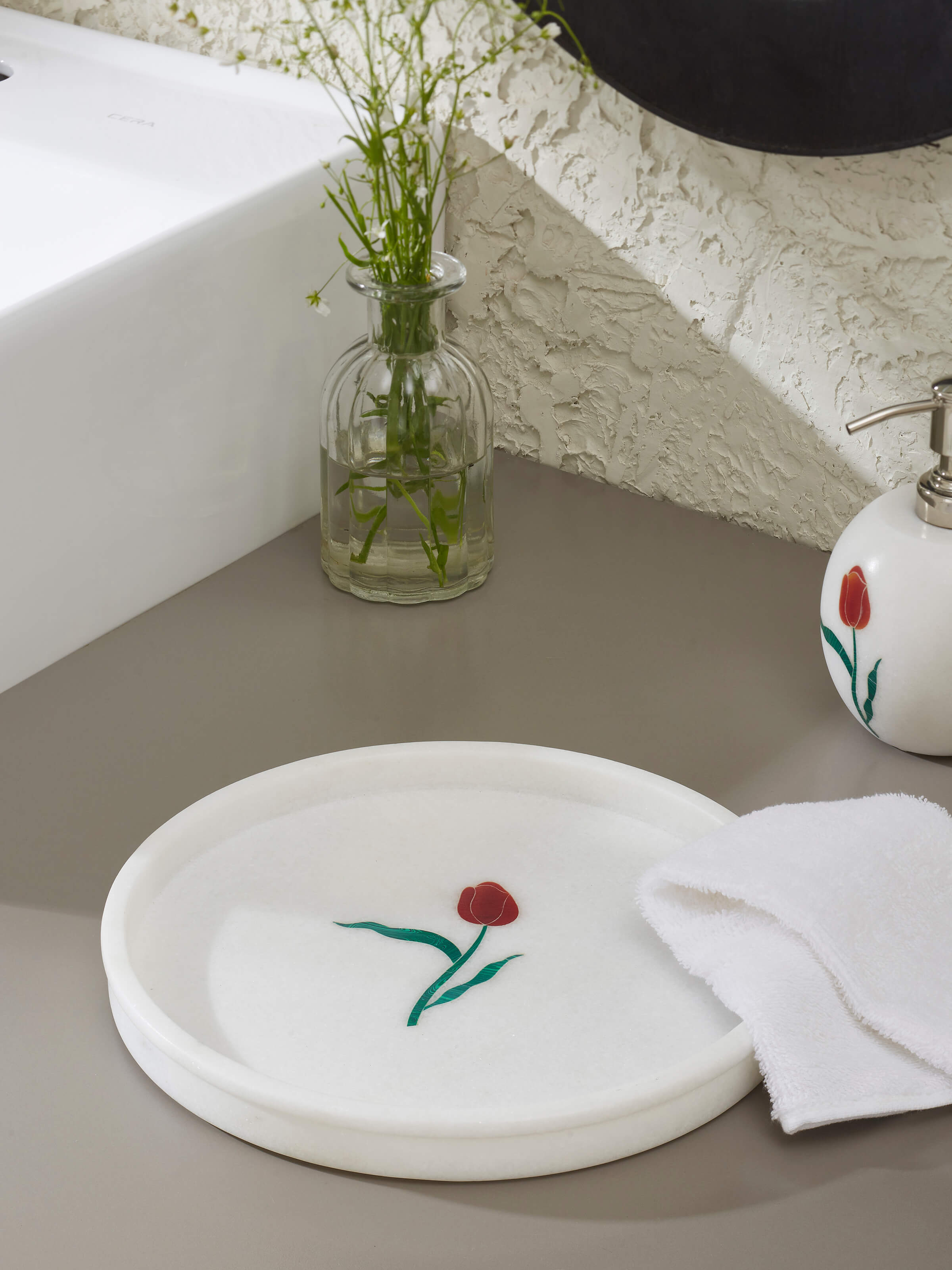 Side view of white carved Ambaji marble bath tray highlighting intricate design