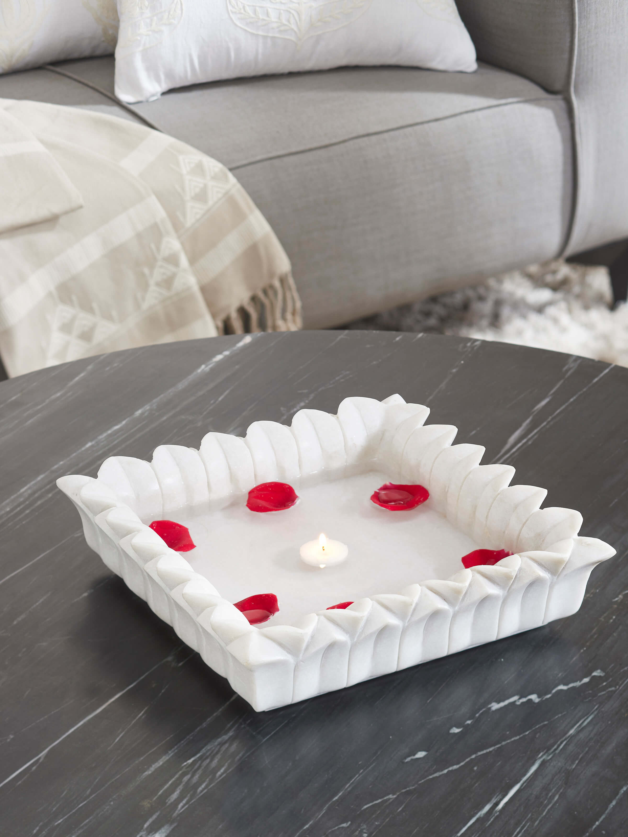 Side view of rectangular carved marble urli highlighting intricate carvings