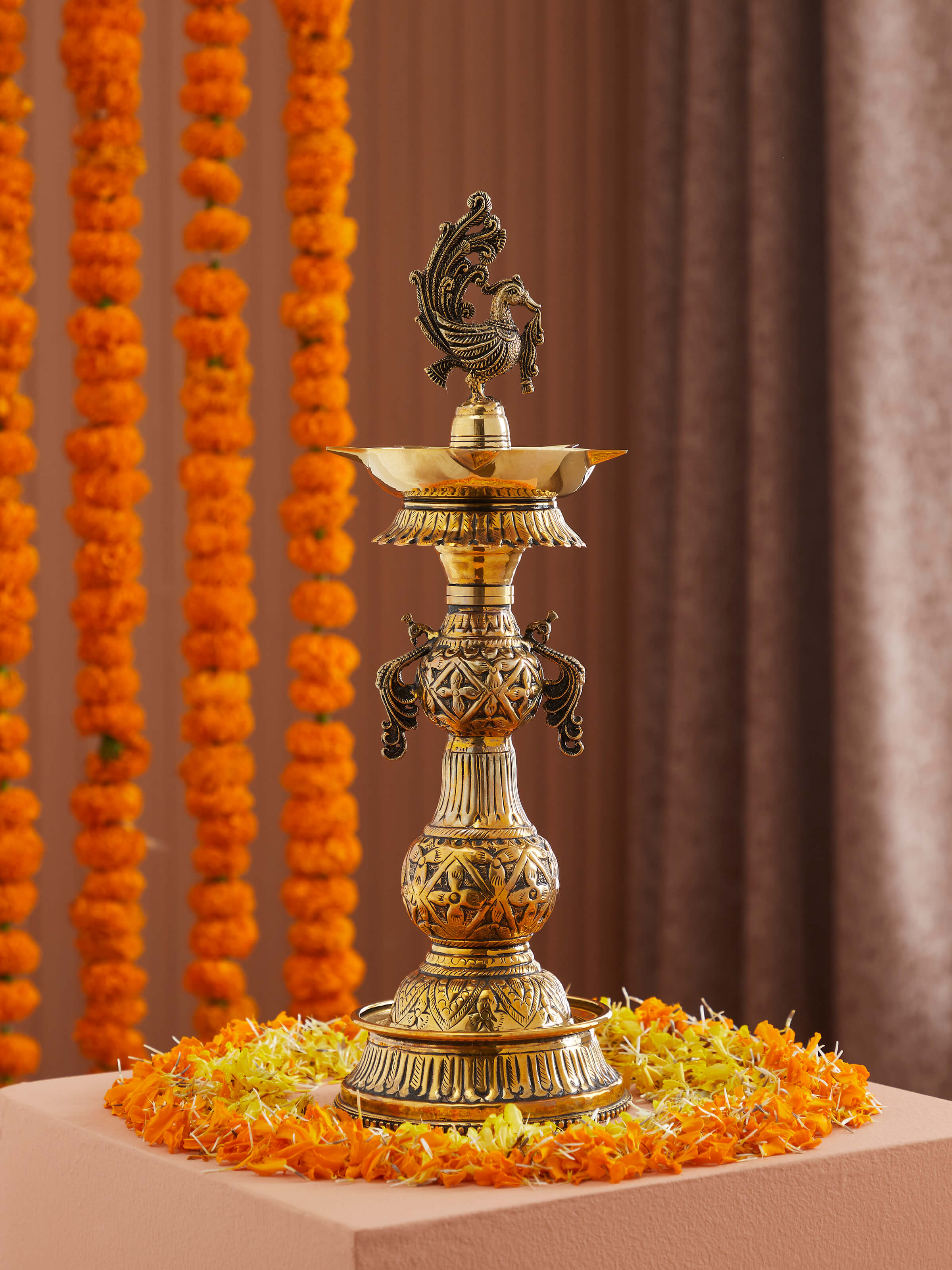 Close-up of Polished brass mayur vilakku showing detailed craftsmanship