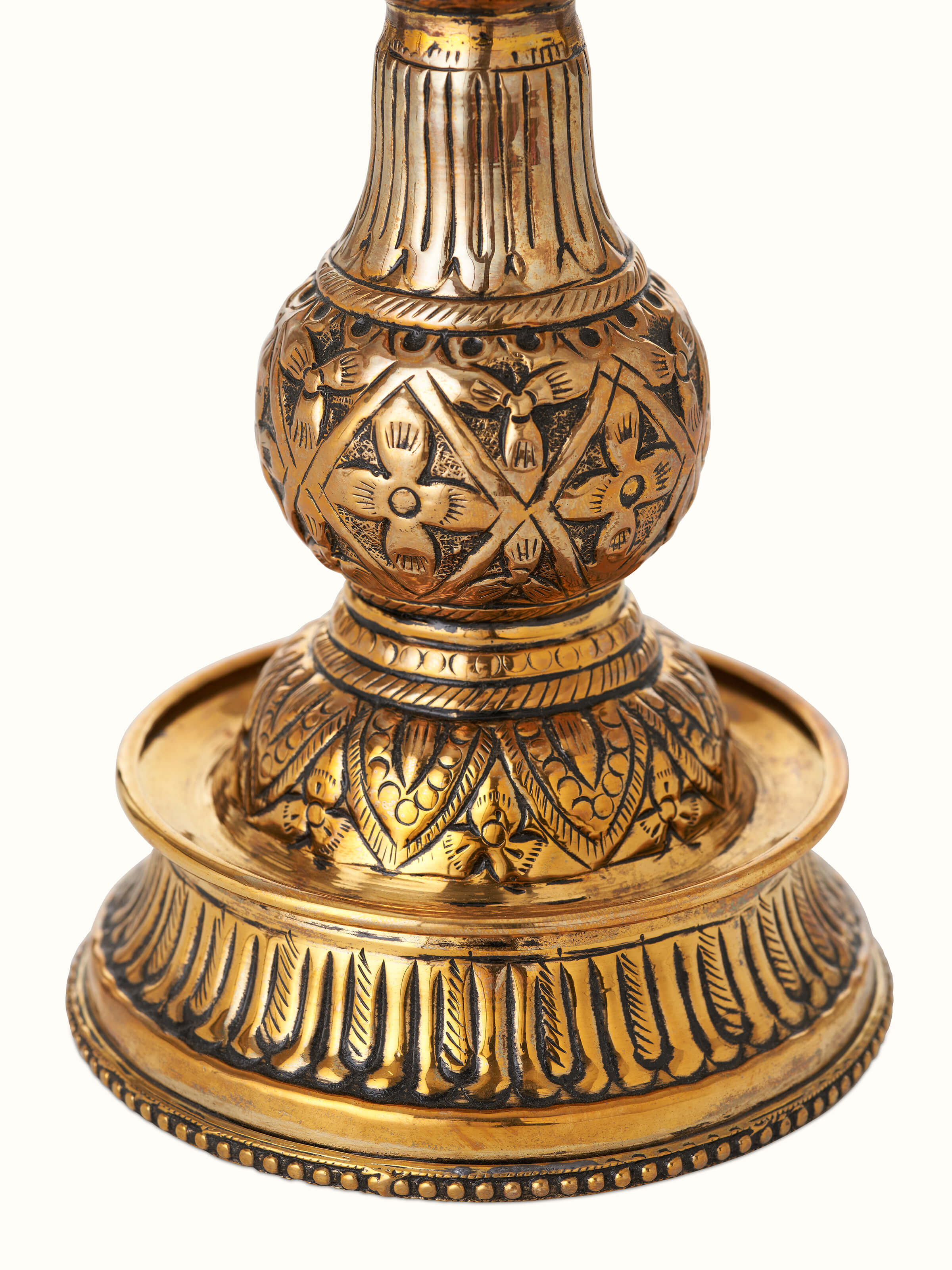 Angled view of Polished brass mayur vilakku displaying elegant detailing