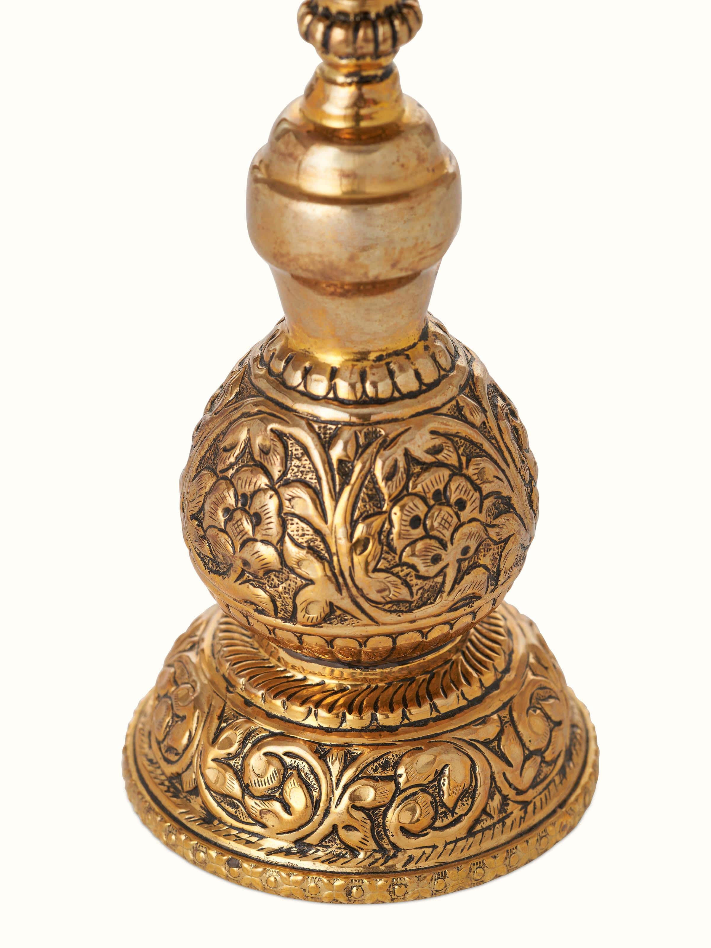 Close-up of polished brass Stambh Vilakku focusing on intricate details and brass texture