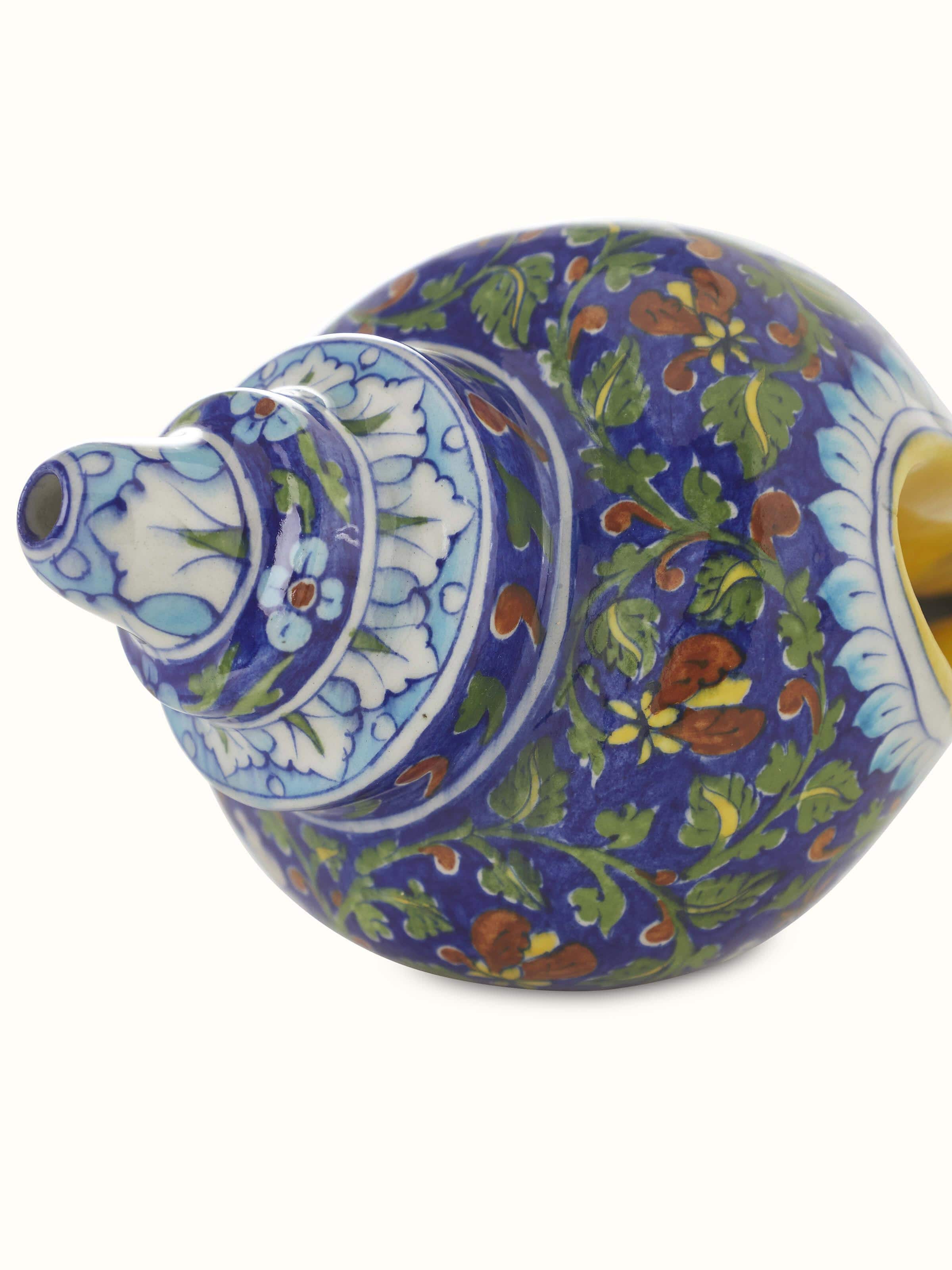 Angled view of Blue pottery ceramic garden shell artpiece highlighting the intricate patterns and rich blue glaze