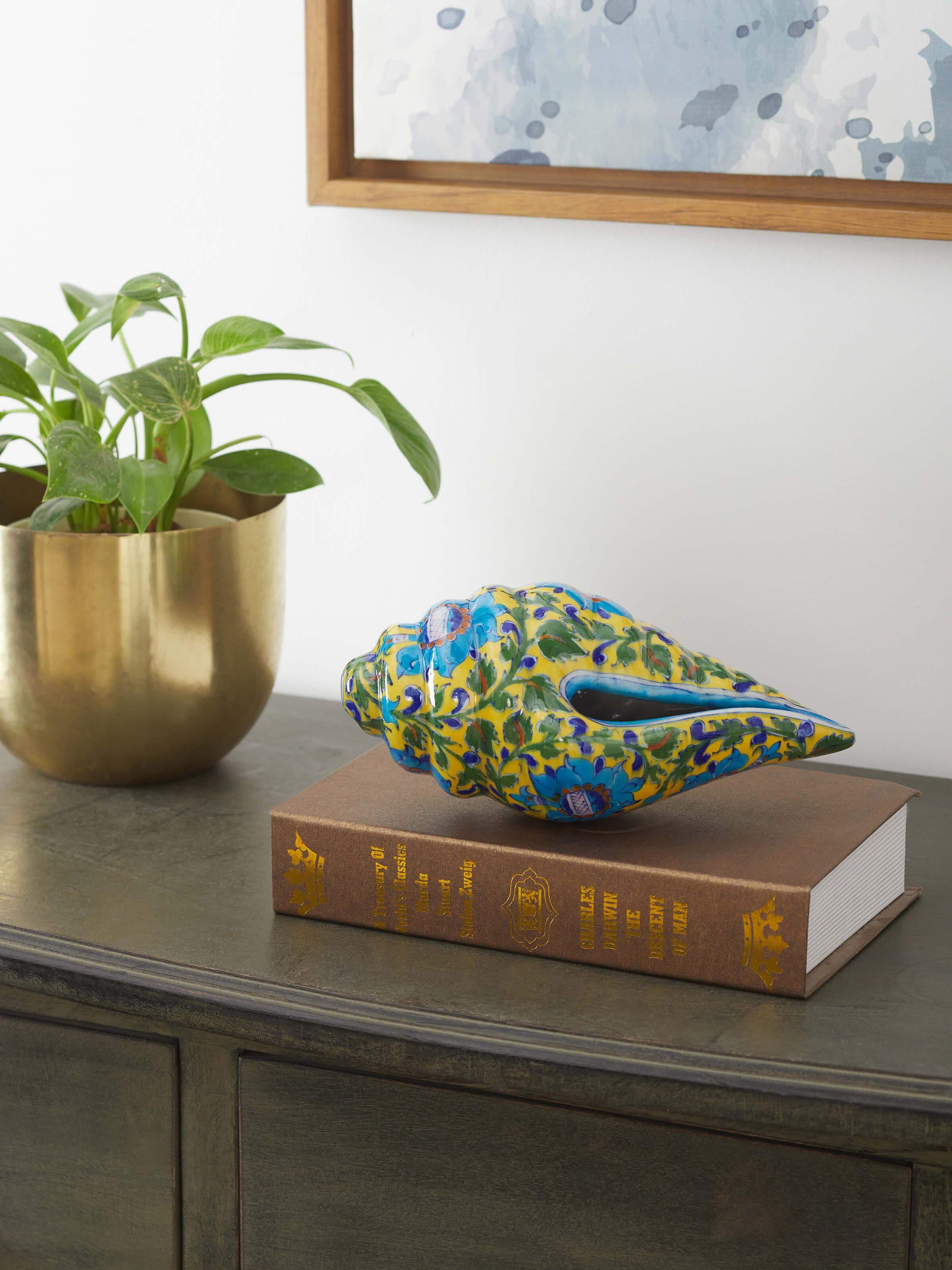 Side view of blue pottery ceramic lotus shell artpiece in green color highlighting detailed craftsmanship