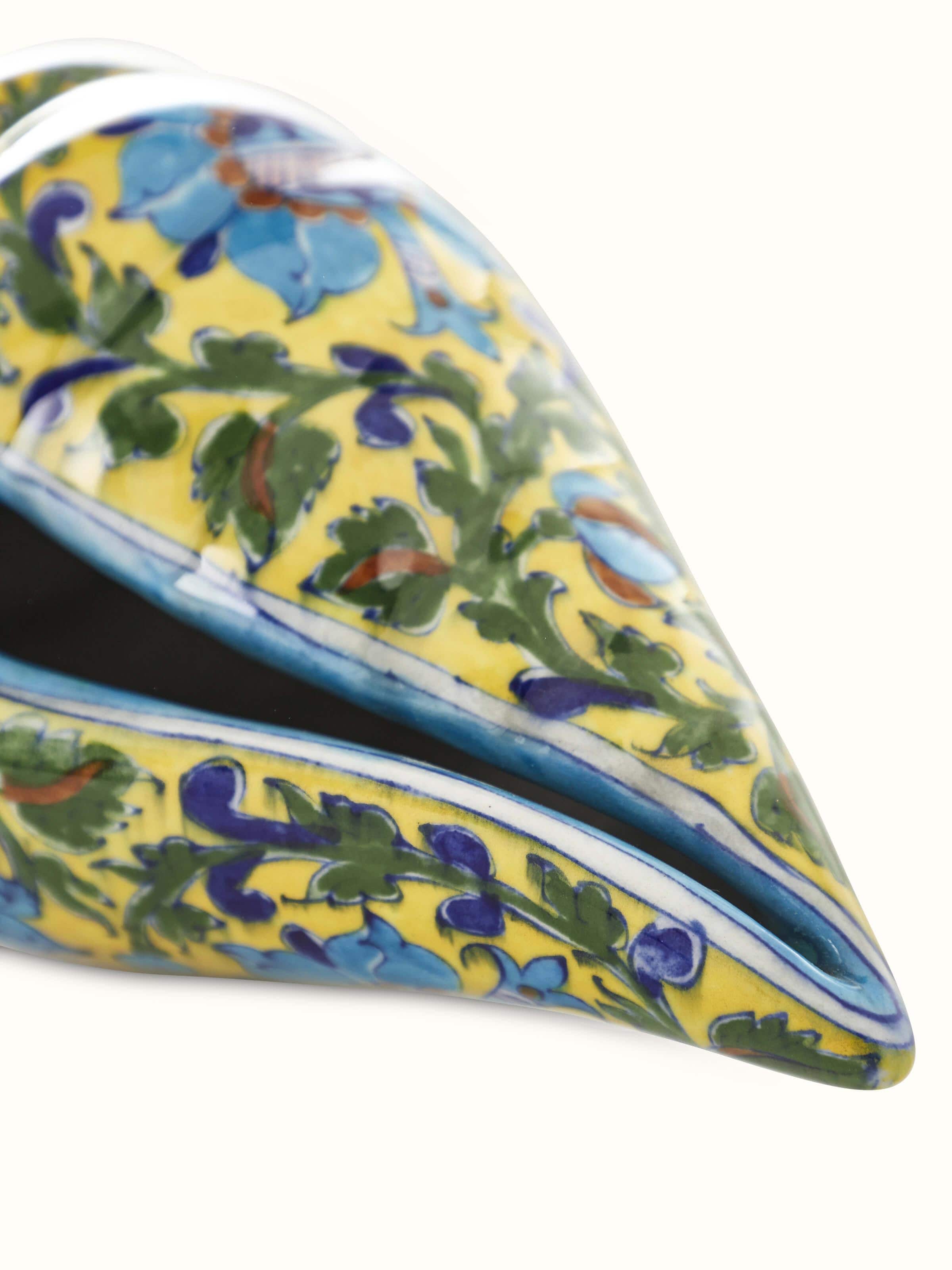 Close-up view of blue pottery ceramic lotus shell artpiece in green color emphasizing decorative patterns