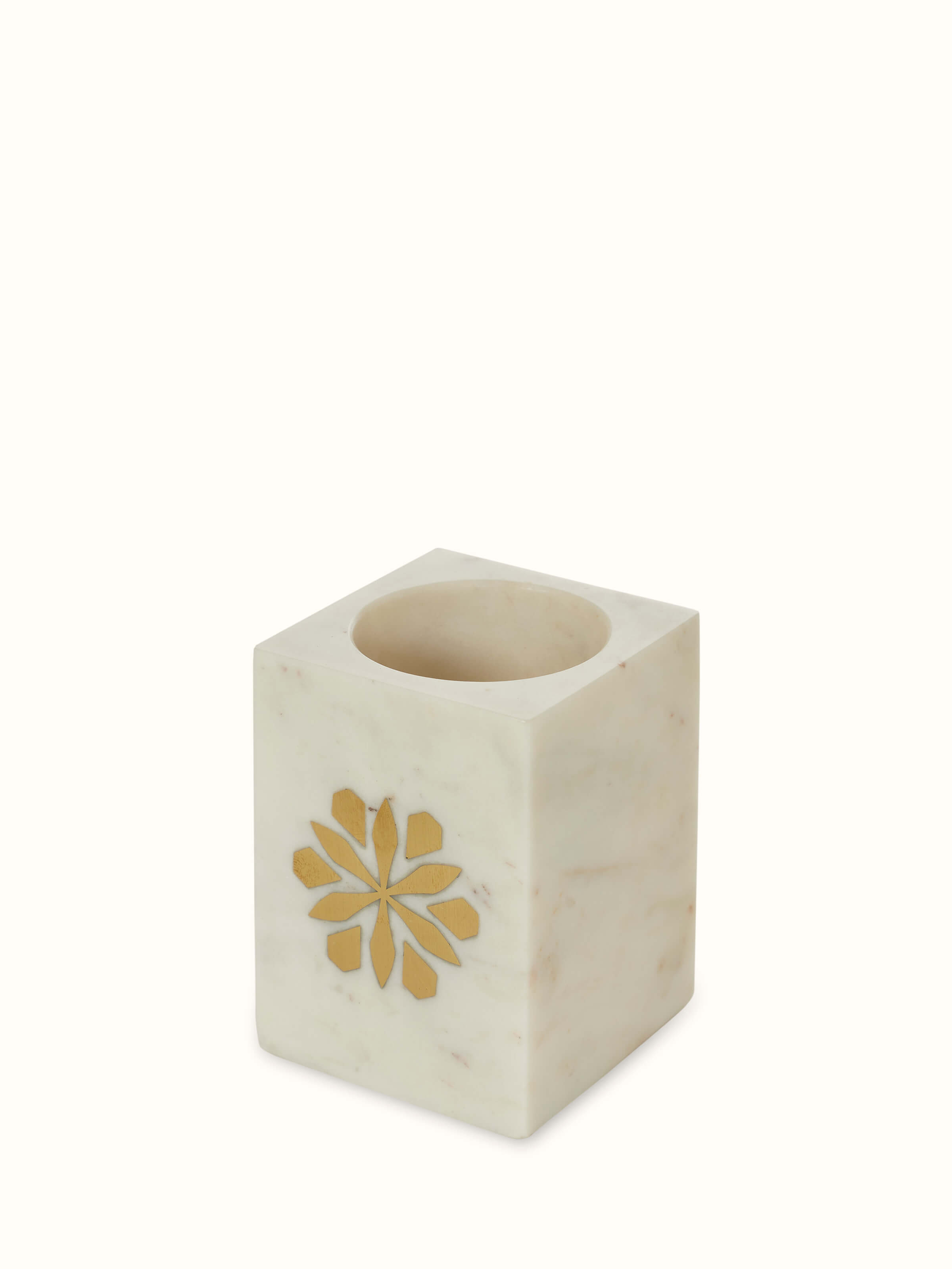 Detailed view of the base of the marble and brass toothbrush holder, showcasing the smooth stone texture and brass accents.