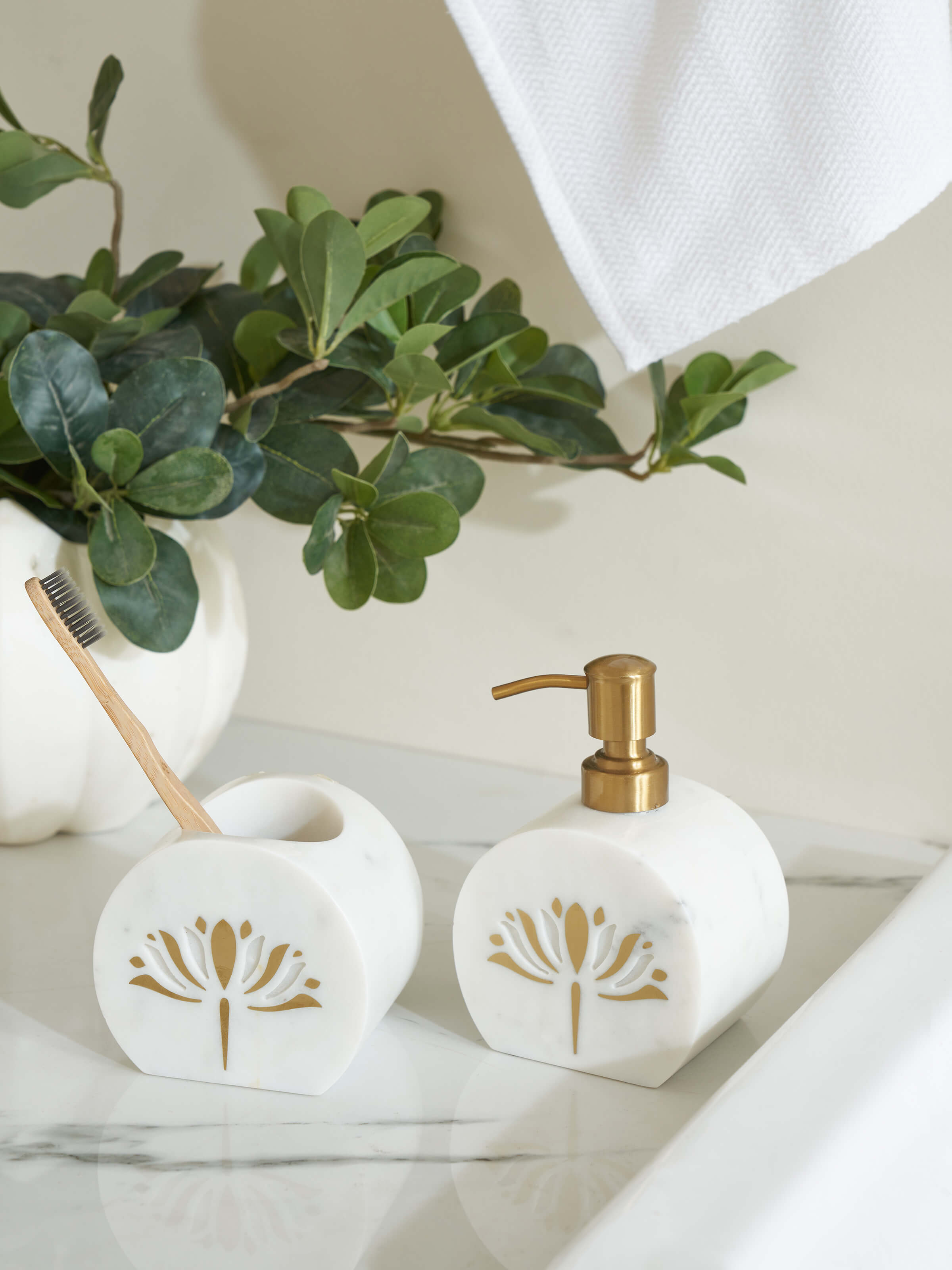 Side view of stone-worked marble and brass soap dispenser in gold color highlighting its elegant design.