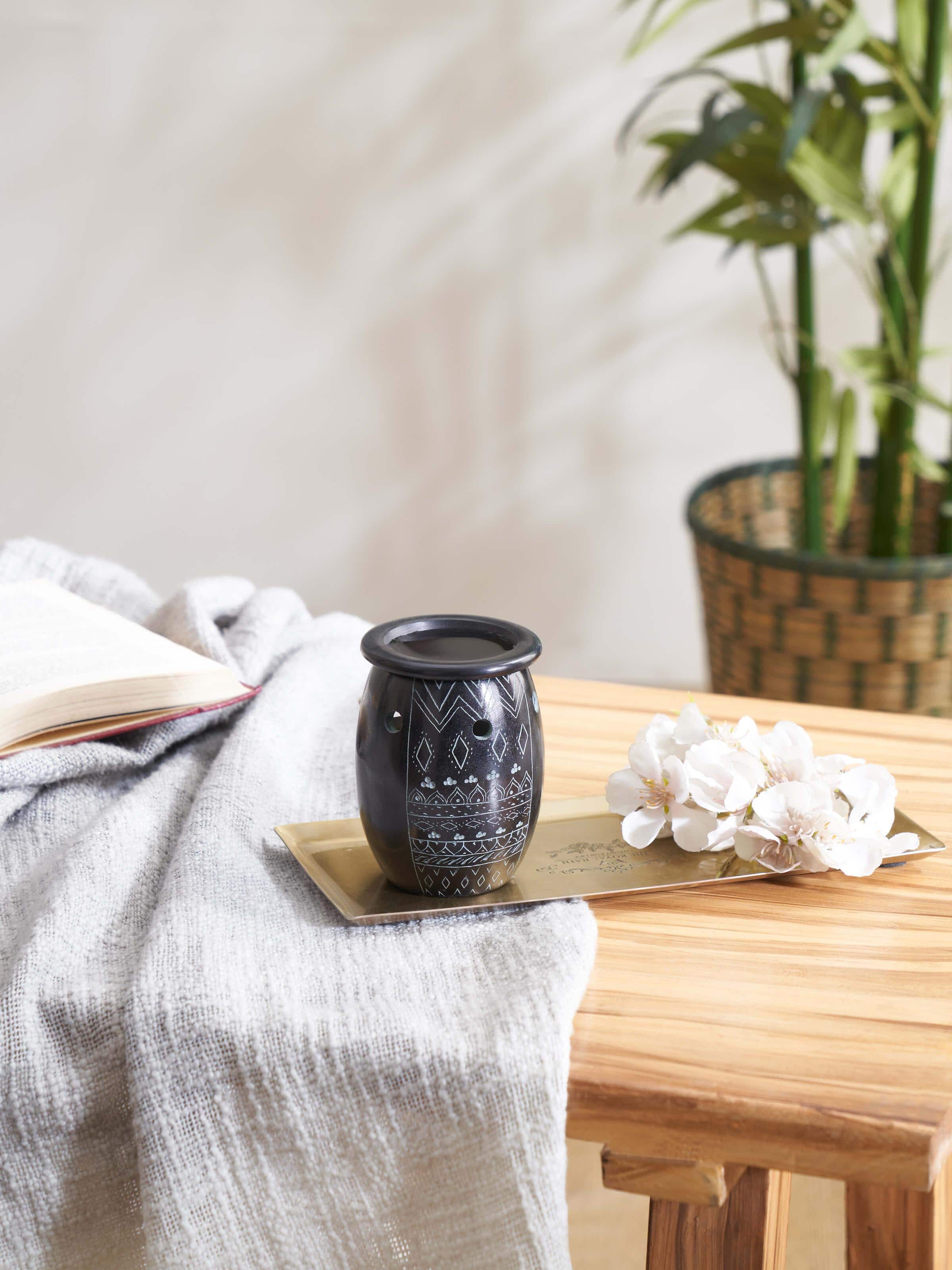 Close-up view of the carved stone diffuser, highlighting the detailed carvings and elegant design.