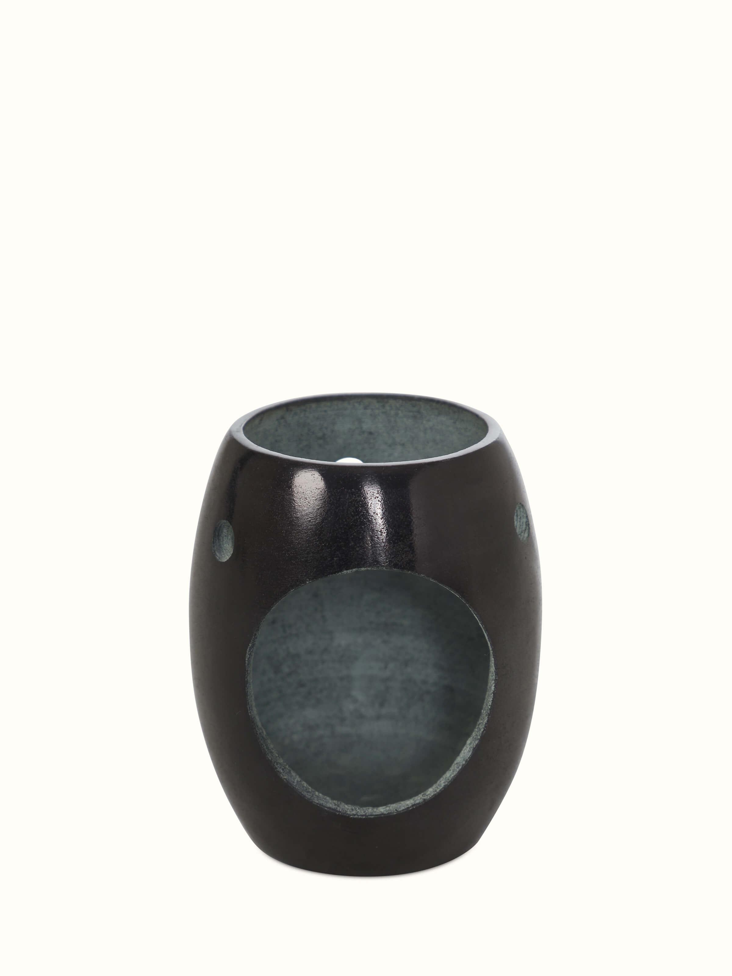 Side view of the carved stone diffuser, showcasing the texture and craftsmanship of the design.