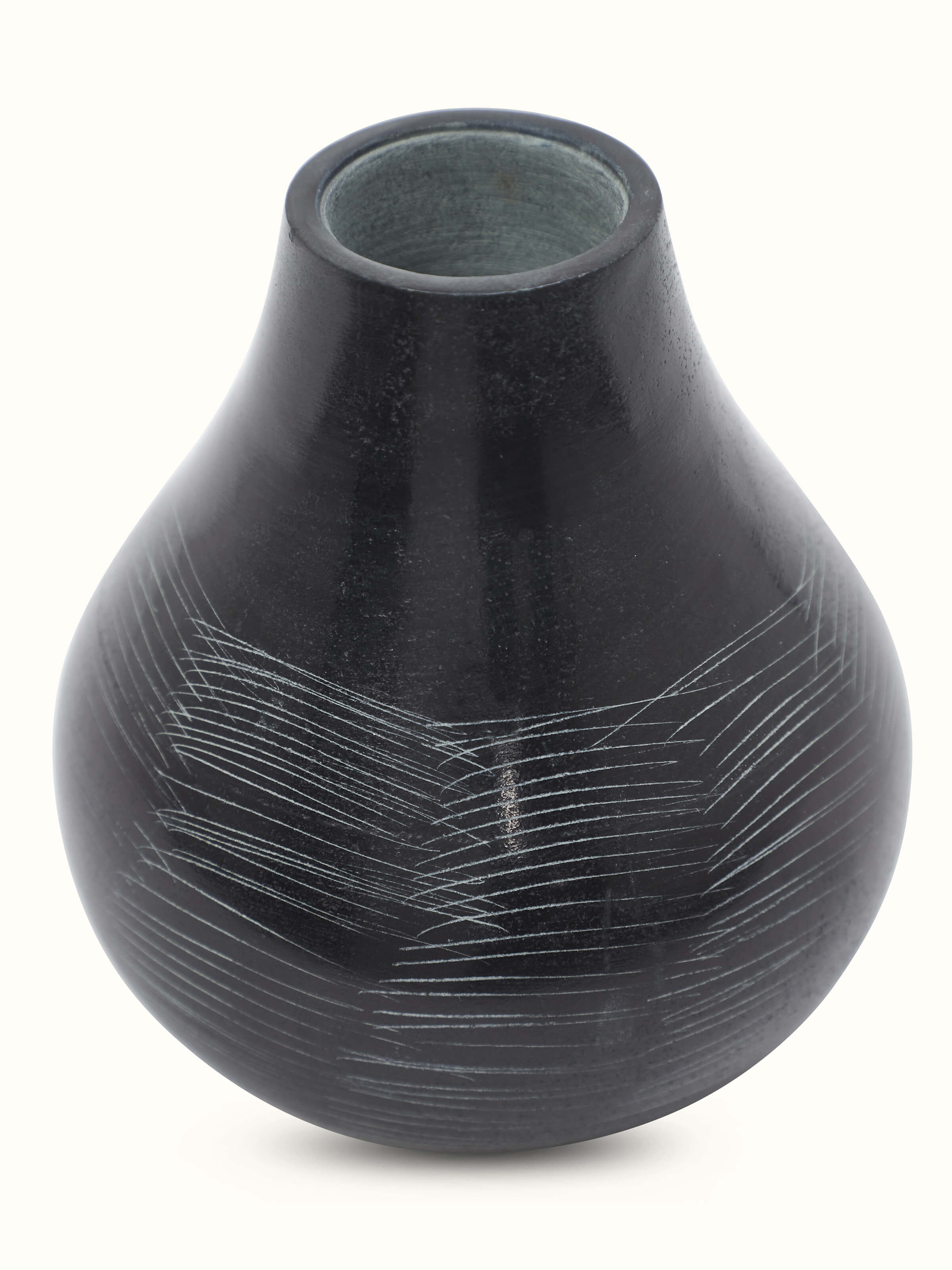 Side angle of carved stone vase in black color highlighting detailed carving and smooth finish