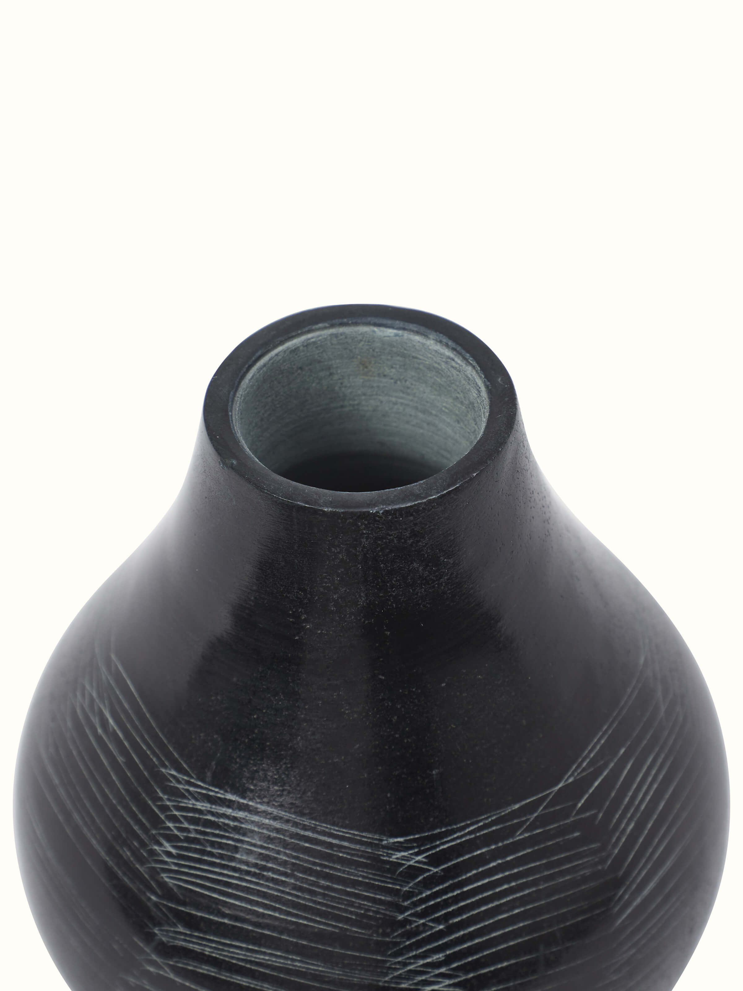 Close-up of carved stone vase in black color showcasing intricate details and craftsmanship
