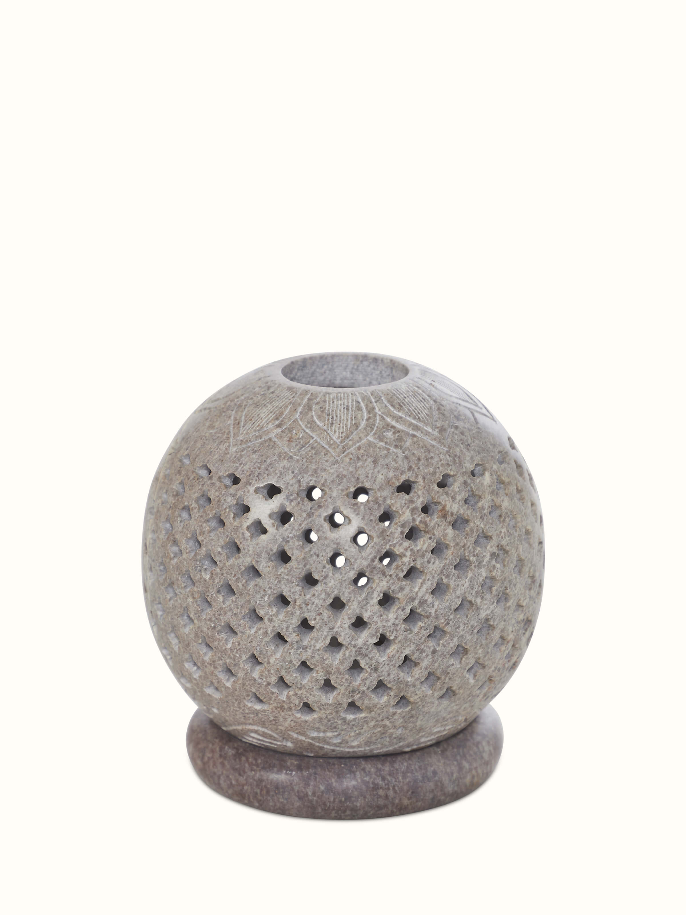 Front view of carved stone tea light holder, showcasing intricate carvings and elegant design